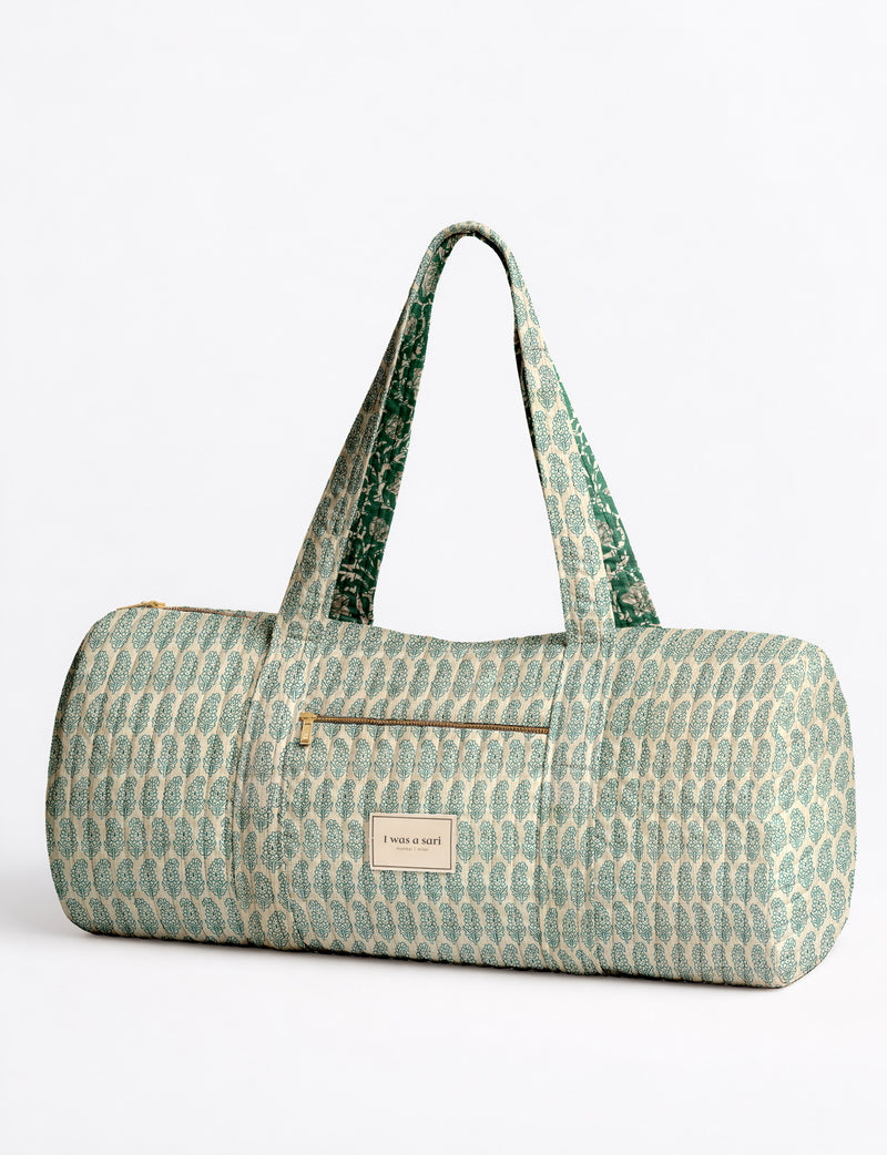 Brown paisley quilted bowling bag with dual handles, front zipper pocket, and "I was a sari" label on front side