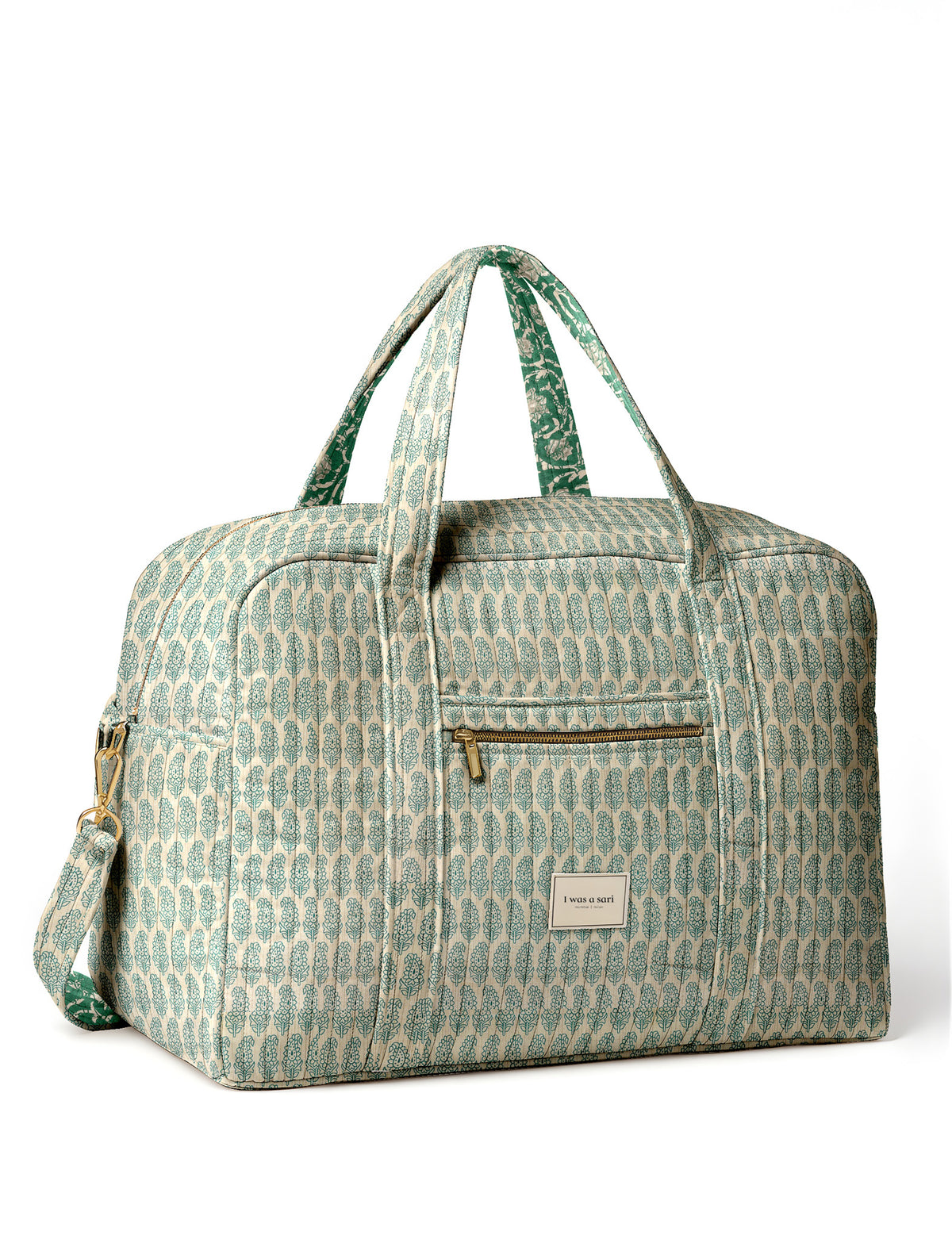 Brown quilted duffle bag with paisley pattern, front zip pocket, dual handles, and label reading "I was a sari"