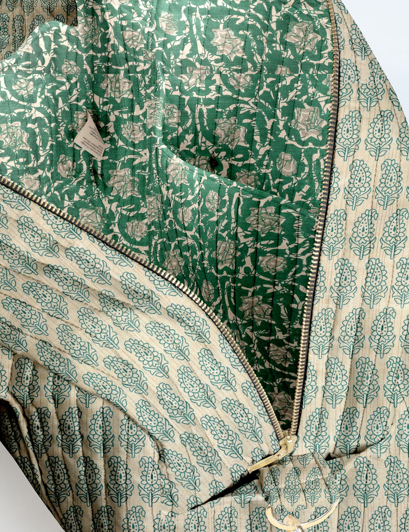 Brown quilted duffle bag with paisley pattern, front zip pocket, dual handles, and label reading "I was a sari"