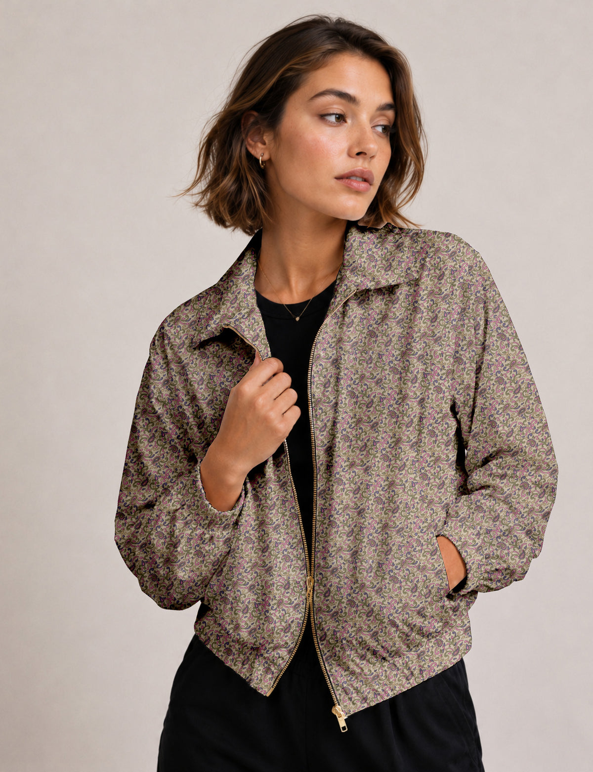 Woman wearing a yellow floral bomber jacket with front zipper, elastic cuffs, and side pockets, shown from front view