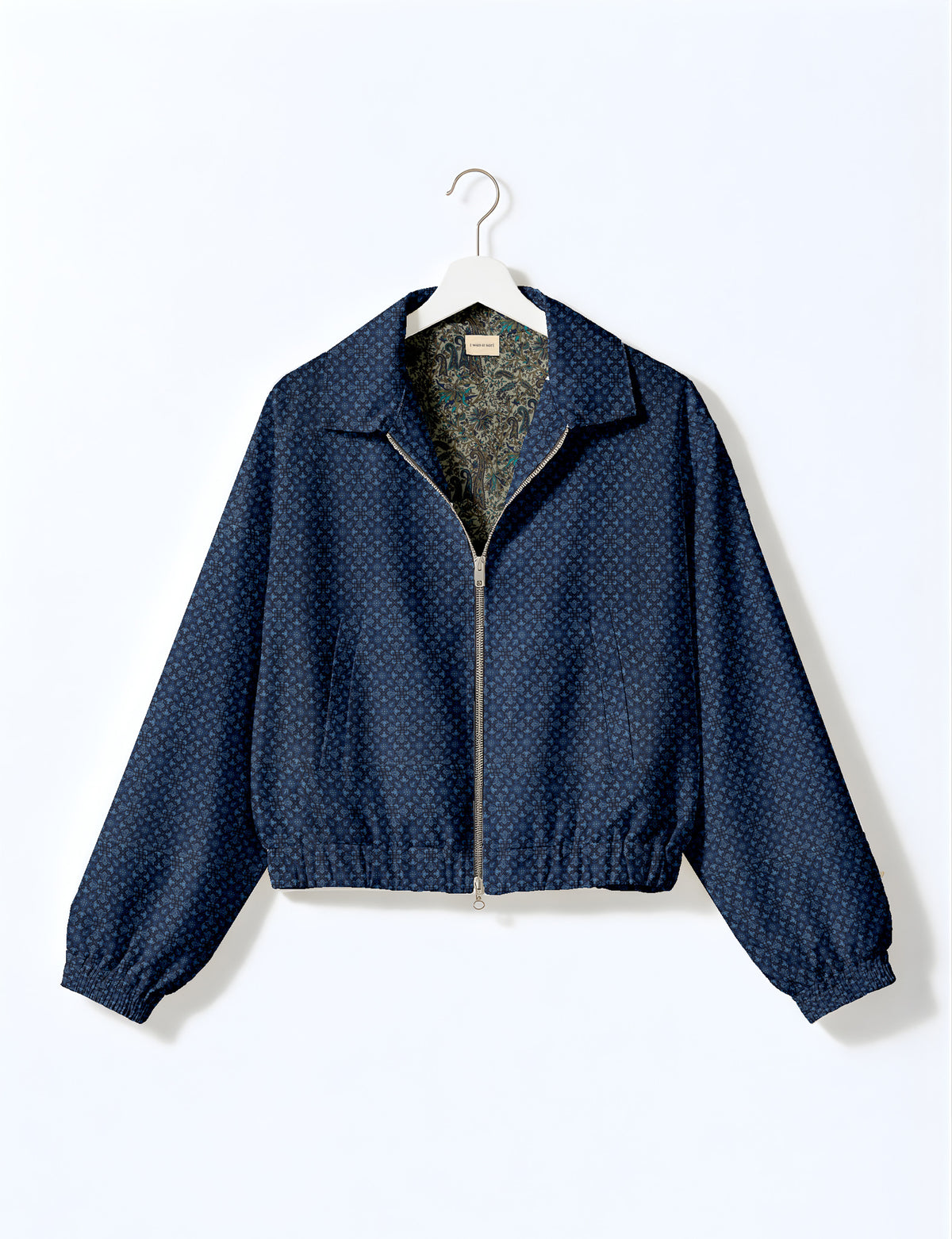 Brown floral bomber jacket with front zipper, elastic cuffs and hem, hanging on white hanger, red floral inner lining visible