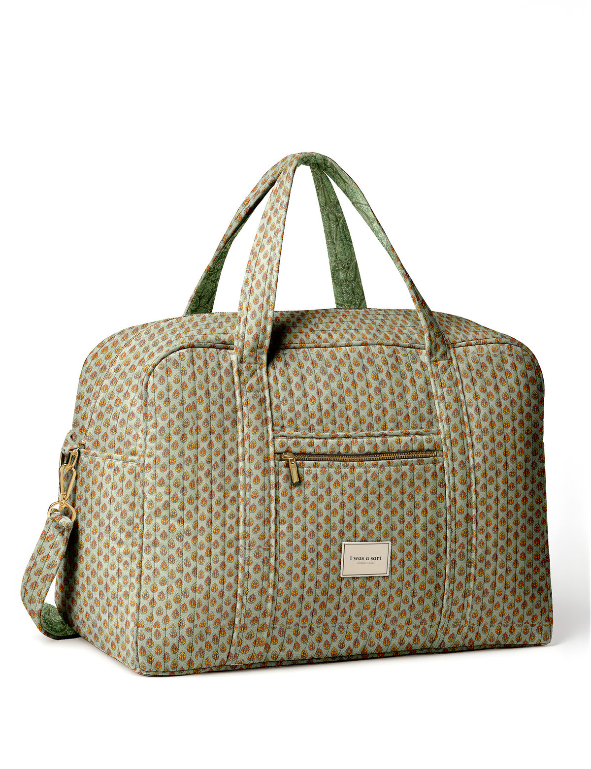 Brown quilted duffle bag with paisley pattern, front zip pocket, dual handles, and label reading "I was a sari"
