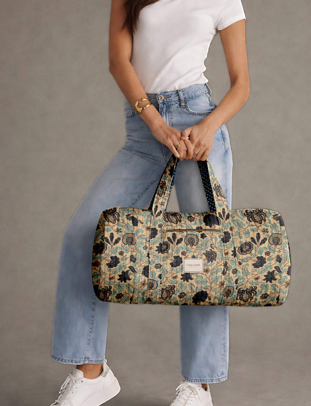 Brown paisley quilted bowling bag with dual handles, front zipper pocket, and "I was a sari" label on front side