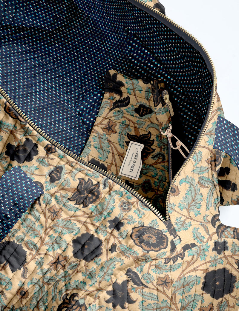 Brown paisley quilted bowling bag with dual handles, front zipper pocket, and "I was a sari" label on front side