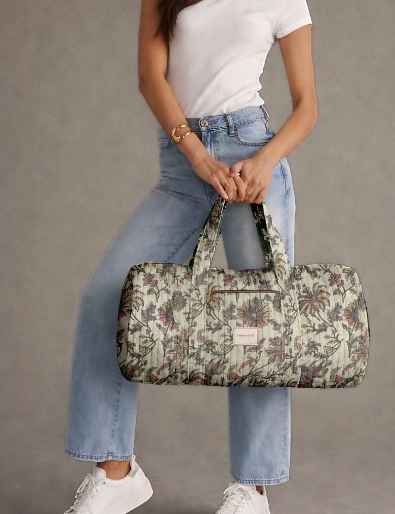 Brown paisley quilted bowling bag with dual handles, front zipper pocket, and "I was a sari" label on front side