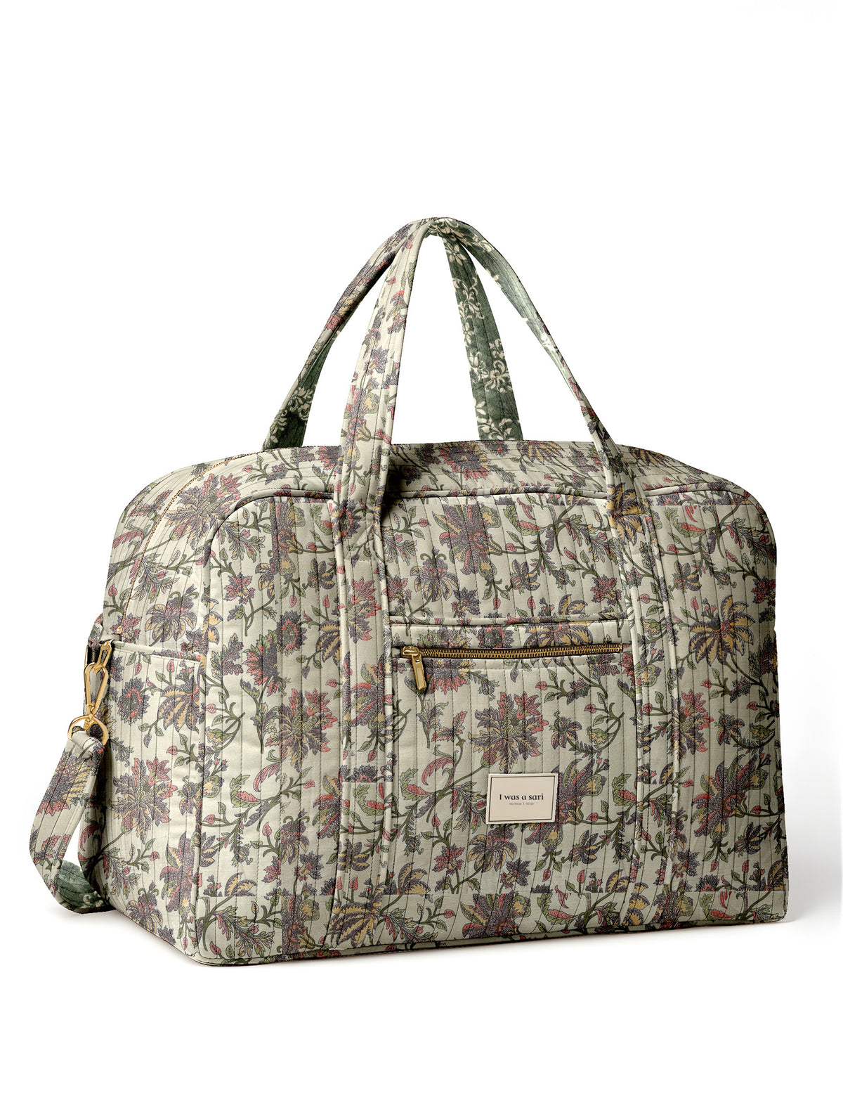 Brown quilted duffle bag with paisley pattern, front zip pocket, dual handles, and label reading "I was a sari"