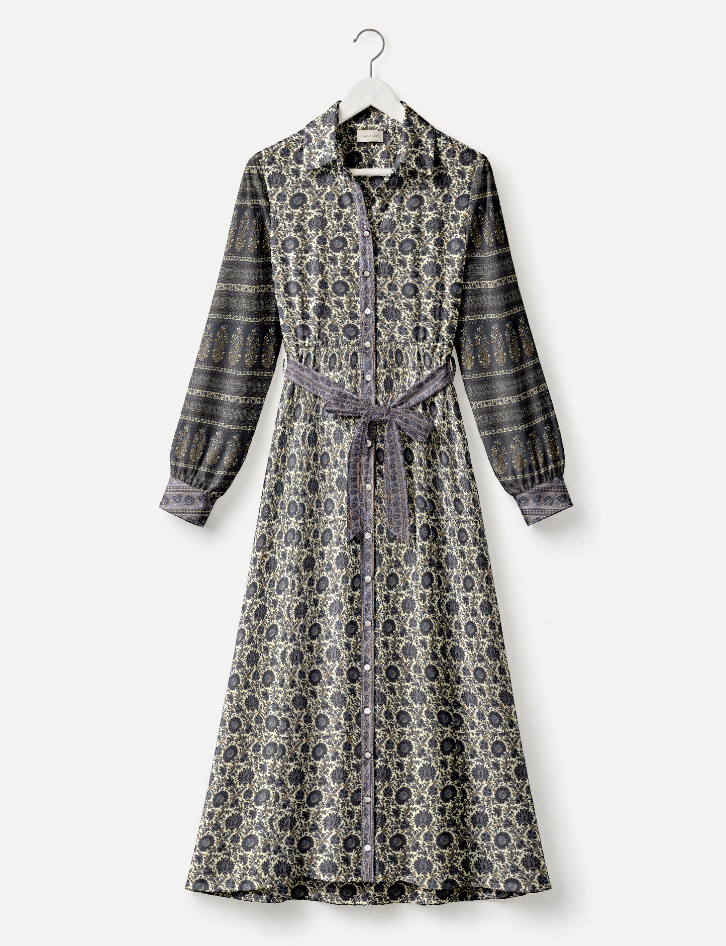 Long shirt dress with beige and dark blue floral and stripe patterns, button front, long sleeves, and waist tie, hanging on