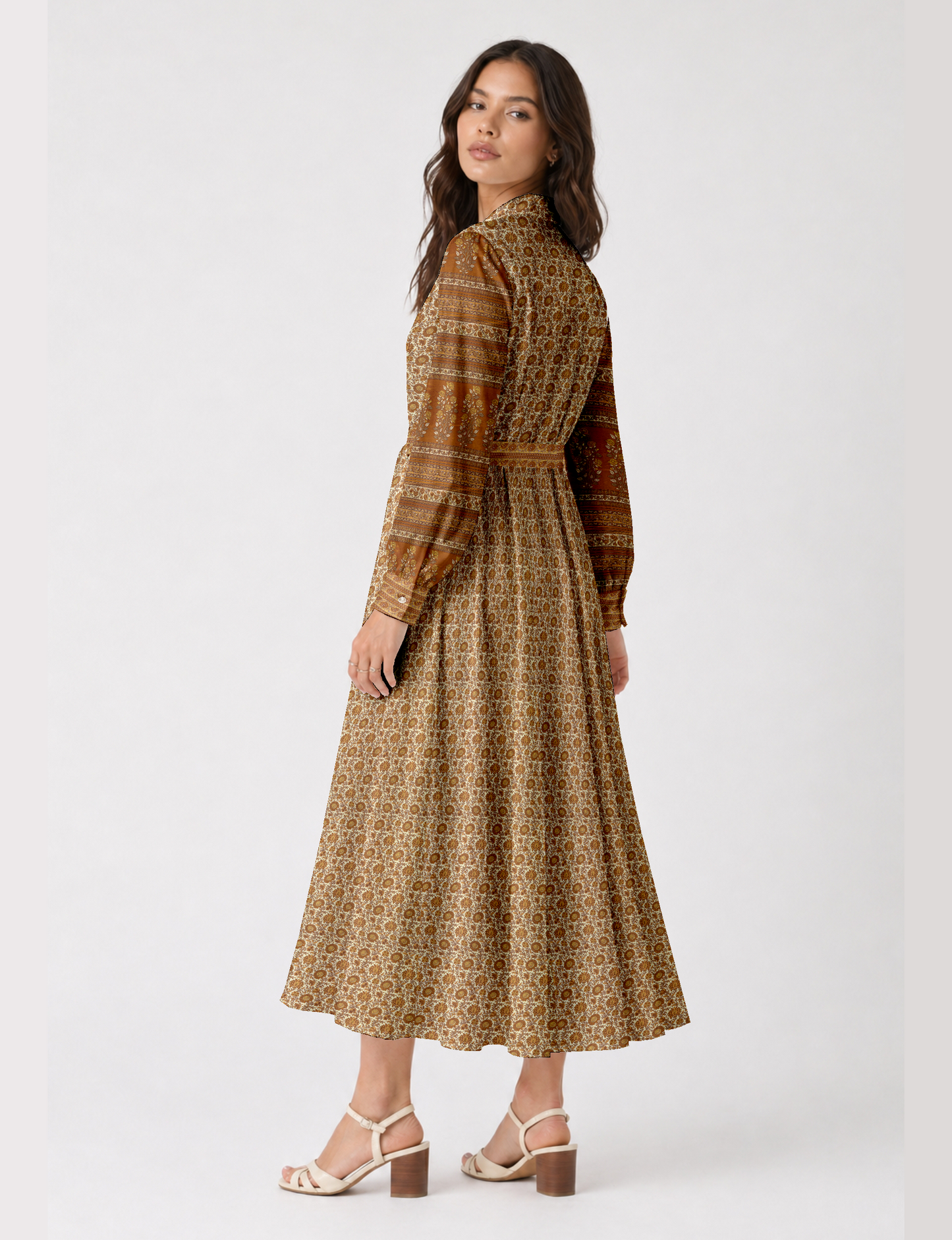 Woman wearing a beige long shirt dress with tropical floral and stripe patterns, long sleeves, and buttoned cuffs, back view