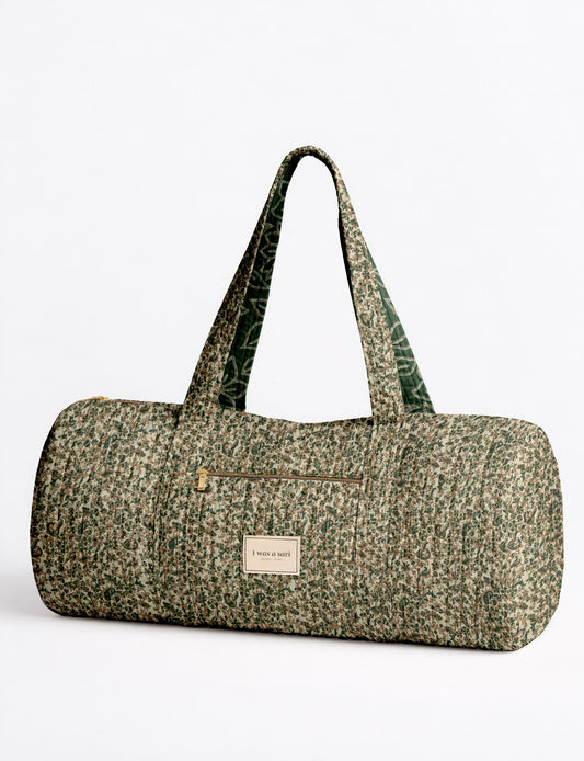 Quilted bowling bag by I Was A Sari with a structured design, featuring dual handles, zip closure, and a spacious interior with an outer zip pocket. Designed for everyday use and travel, it showcases a sleek elongated silhouette with functional storage and easy access compartments. Made from upcycled fabric, this sustainable handbag combines style and practicality, presented through detailed front, side, and lifestyle views.