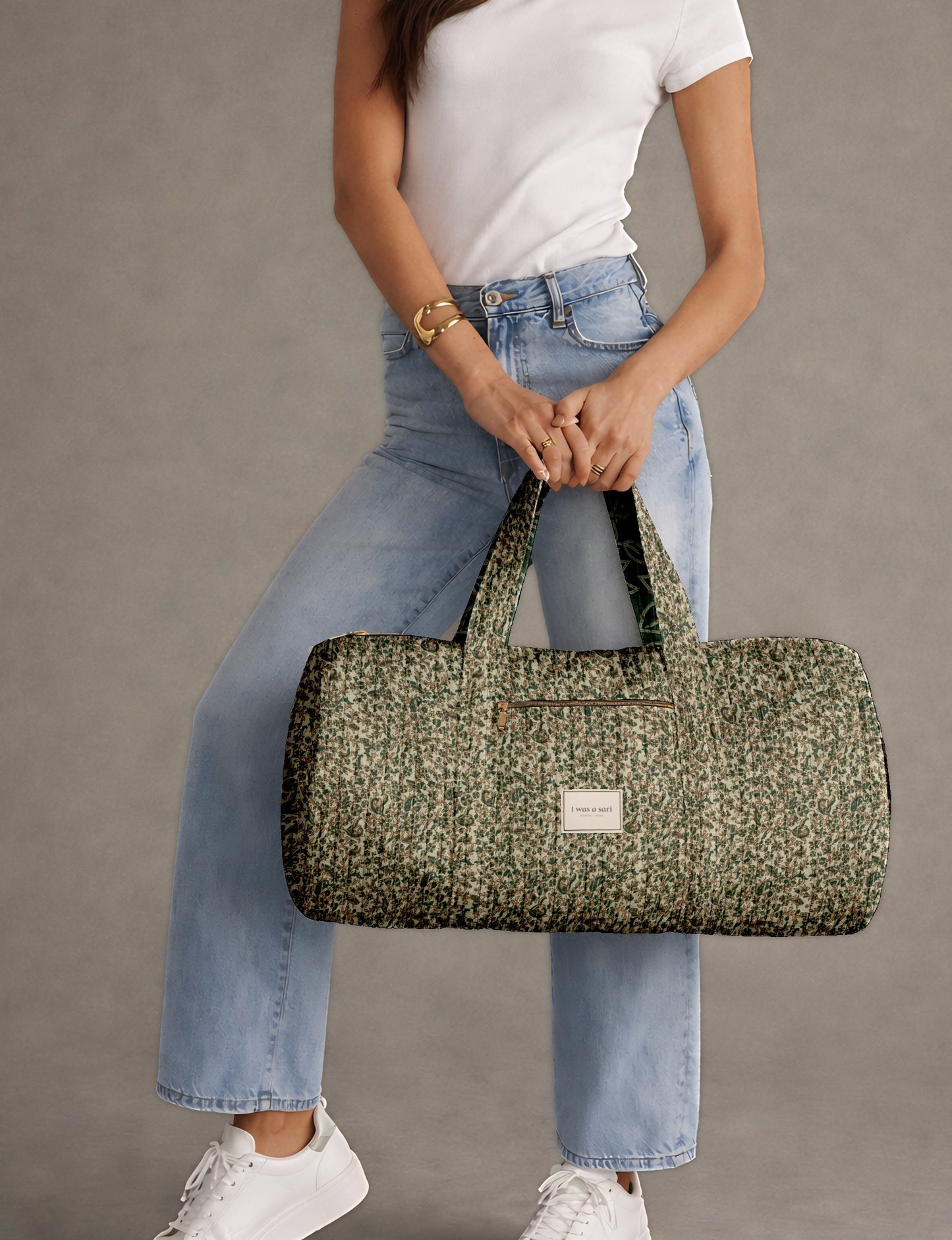 Quilted bowling bag by I Was A Sari with a structured design, featuring dual handles, zip closure, and a spacious interior with an outer zip pocket. Designed for everyday use and travel, it showcases a sleek elongated silhouette with functional storage and easy access compartments. Made from upcycled fabric, this sustainable handbag combines style and practicality, presented through detailed front, side, and lifestyle views.