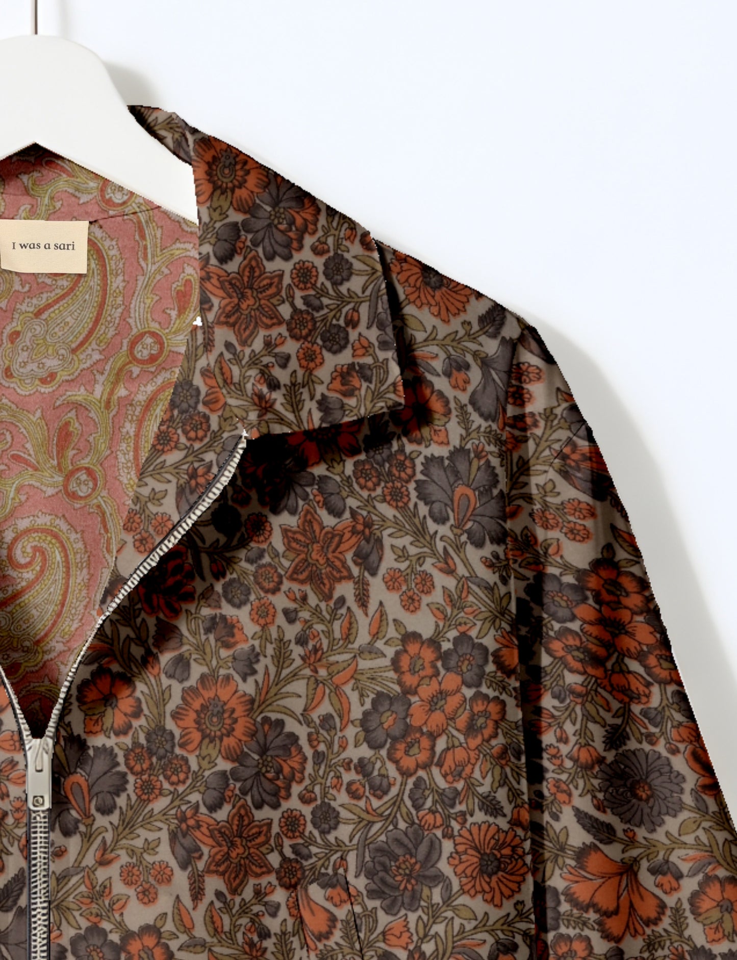 Women's cropped bomber jacket with twin metallic front zippers, welt pockets, elasticated hem and cuffs, and contrast sari print lining.