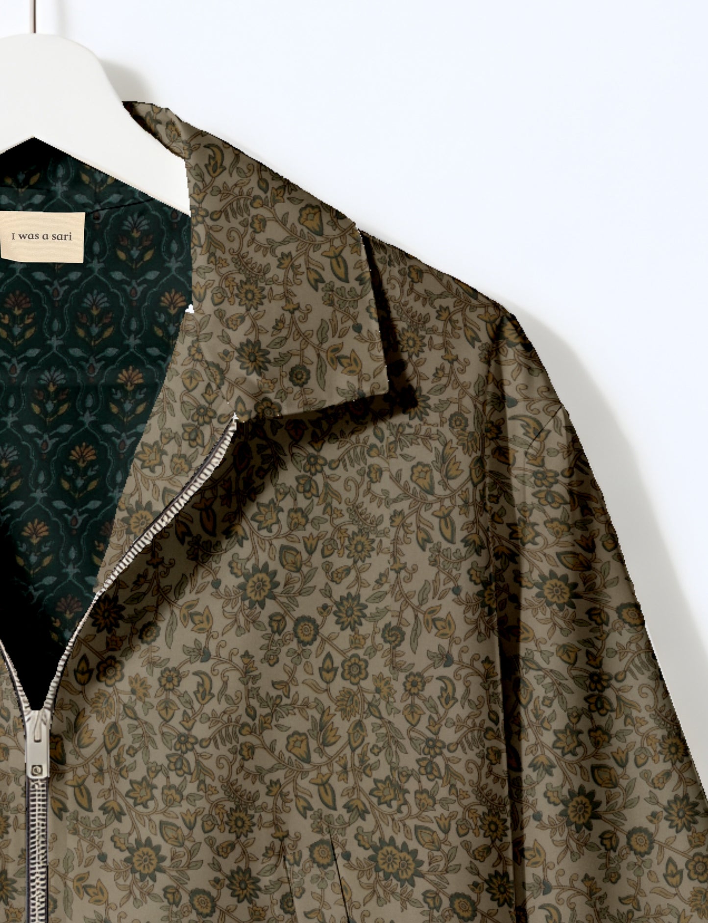 Women's cropped bomber jacket with twin metallic front zippers, welt pockets, elasticated hem and cuffs, and contrast sari print lining.
