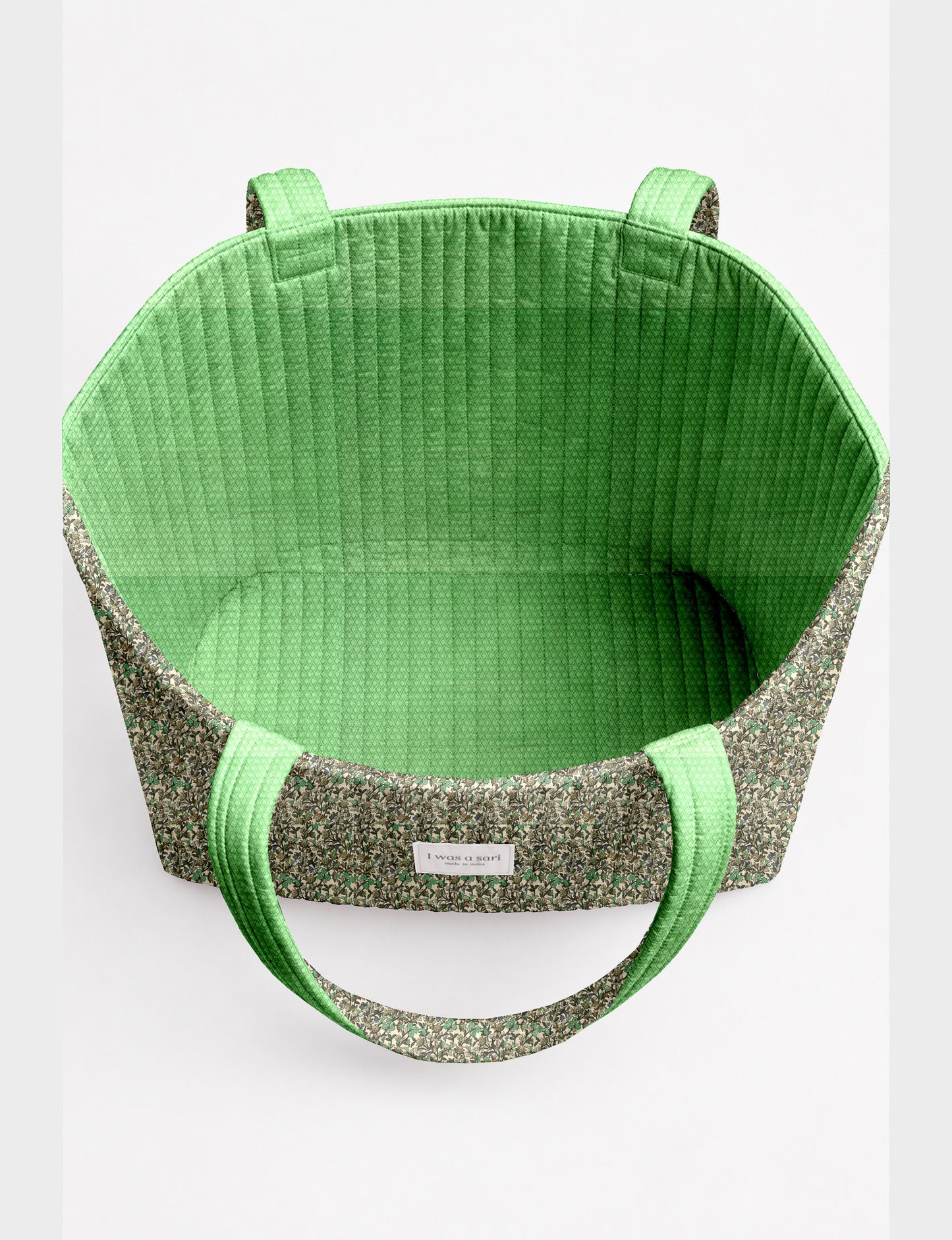Quilted beach bag with yellow tropical exterior and red patterned interior, shown from top view with handles visible