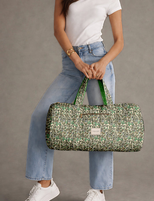 Brown paisley quilted bowling bag with dual handles, front zipper pocket, and "I was a sari" label on front side