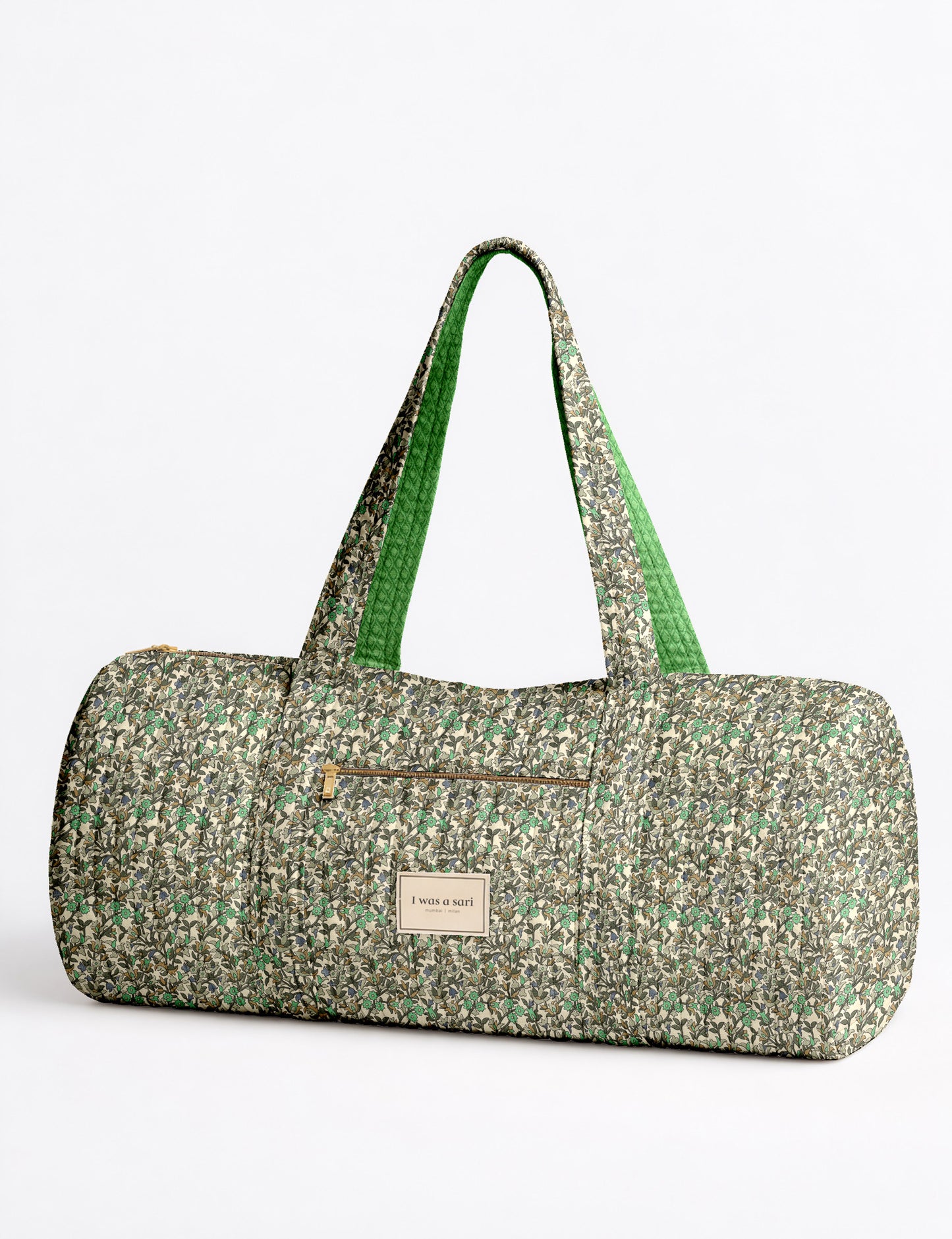 Brown paisley quilted bowling bag with front zipper pocket, held by person wearing white shirt and light blue jeans