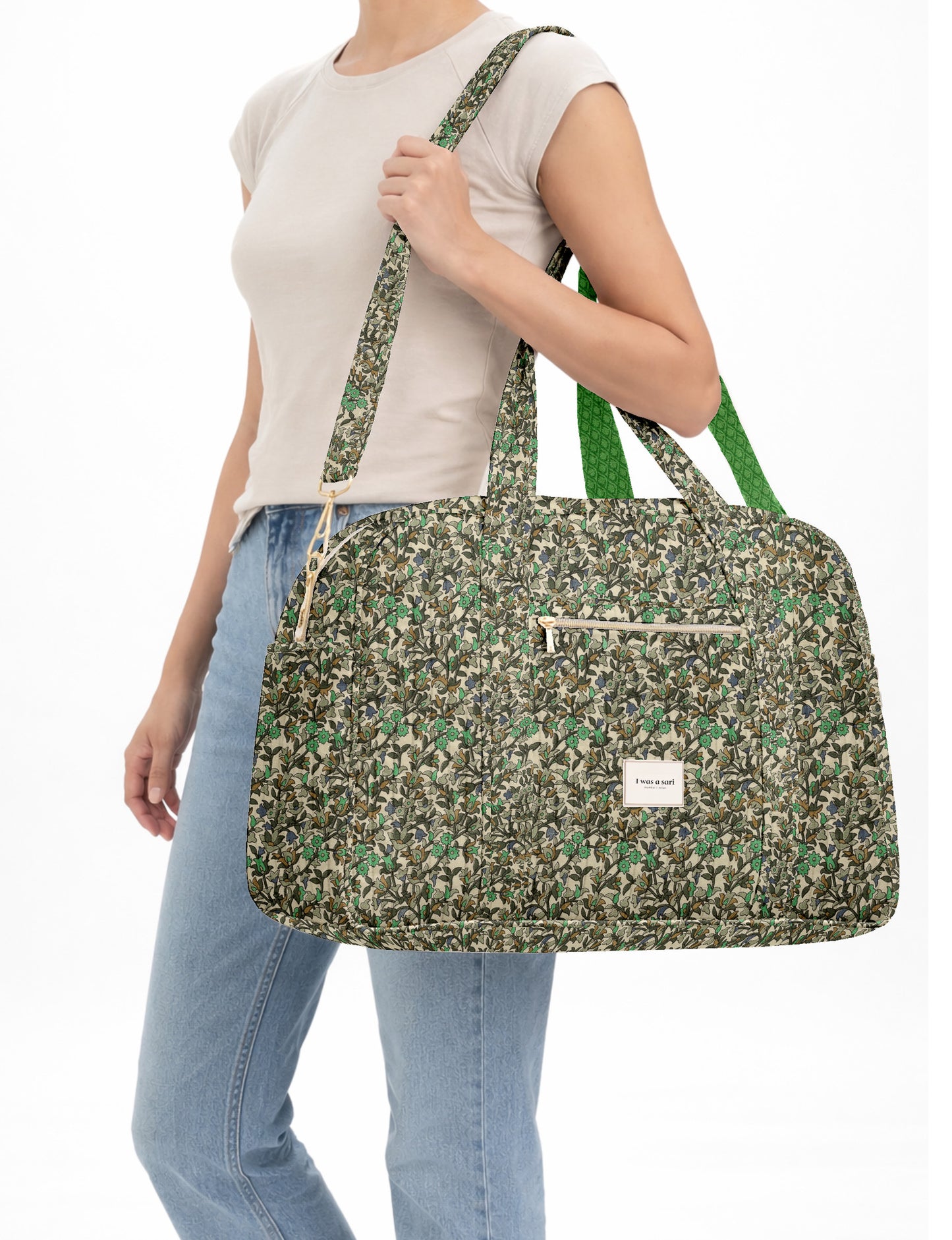 Brown quilted duffle bag with paisley pattern, front zip pocket, dual handles, and label reading "I was a sari"