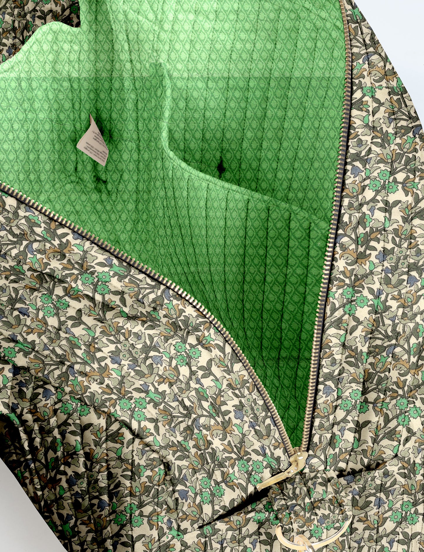 Brown quilted duffle bag with paisley pattern, front zip pocket, dual handles, and label reading "I was a sari"