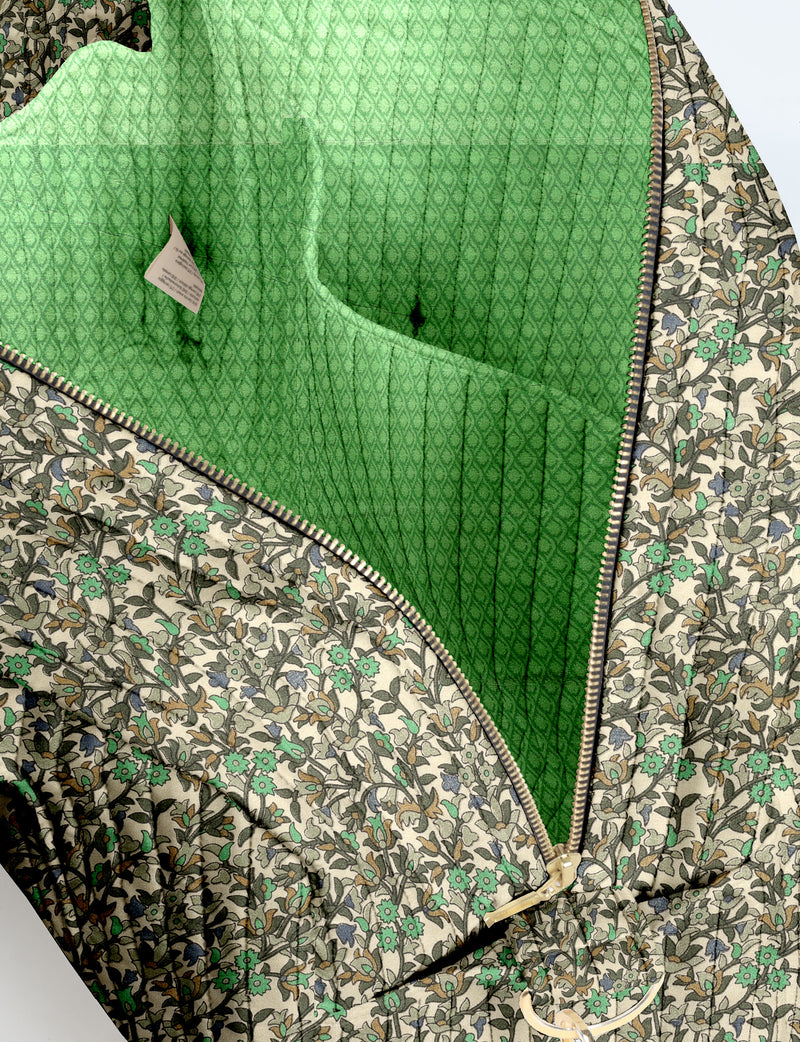Brown quilted duffle bag with paisley pattern, front zip pocket, dual handles, and label reading "I was a sari"