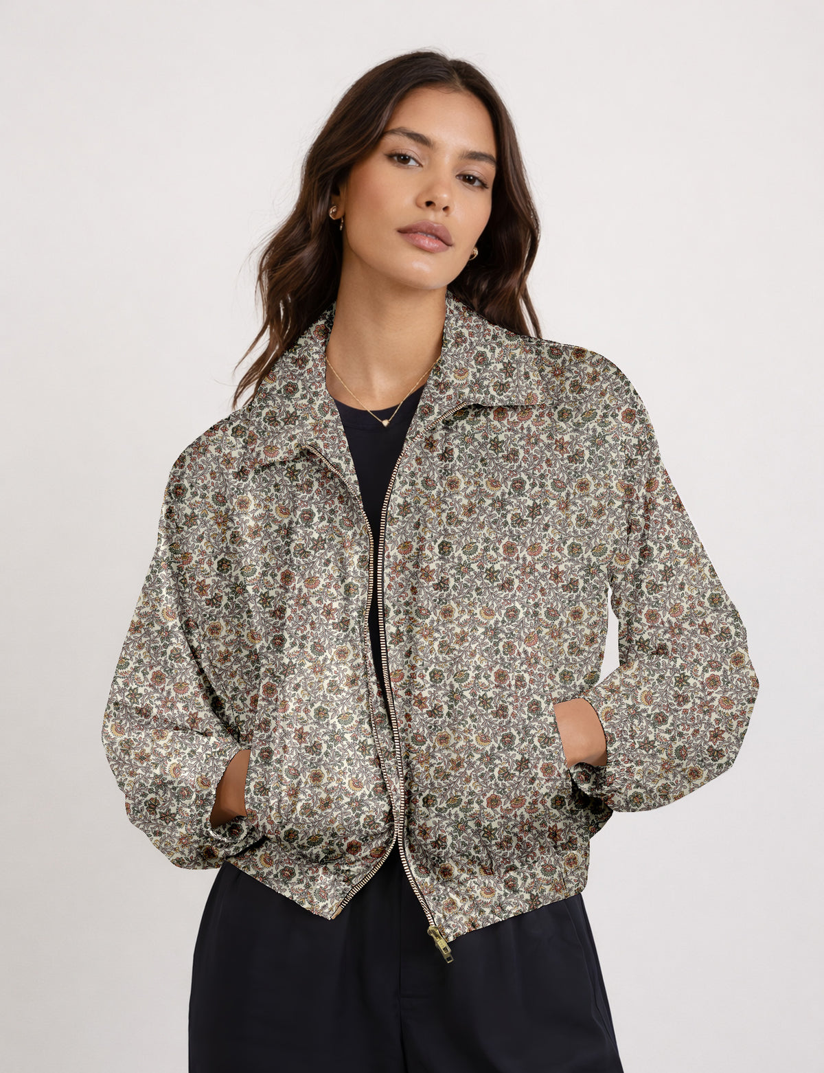 Woman wearing a yellow floral bomber jacket with front zipper, elastic cuffs, and side pockets, shown from front view