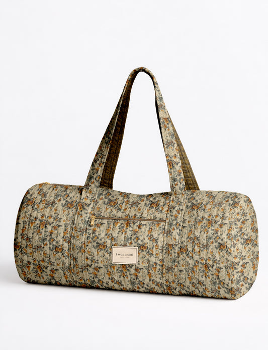 Beige quilted bowling bag with micro floral pattern, front zipper pocket, and dual handles with striped inner lining
