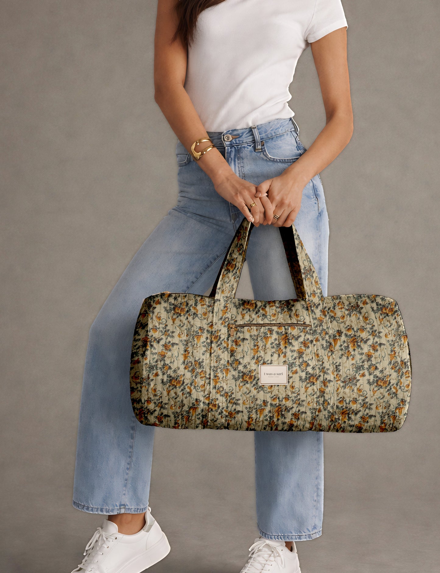 Beige quilted bowling bag with micro floral print exterior and blue geometric patterned interior, open zipper view