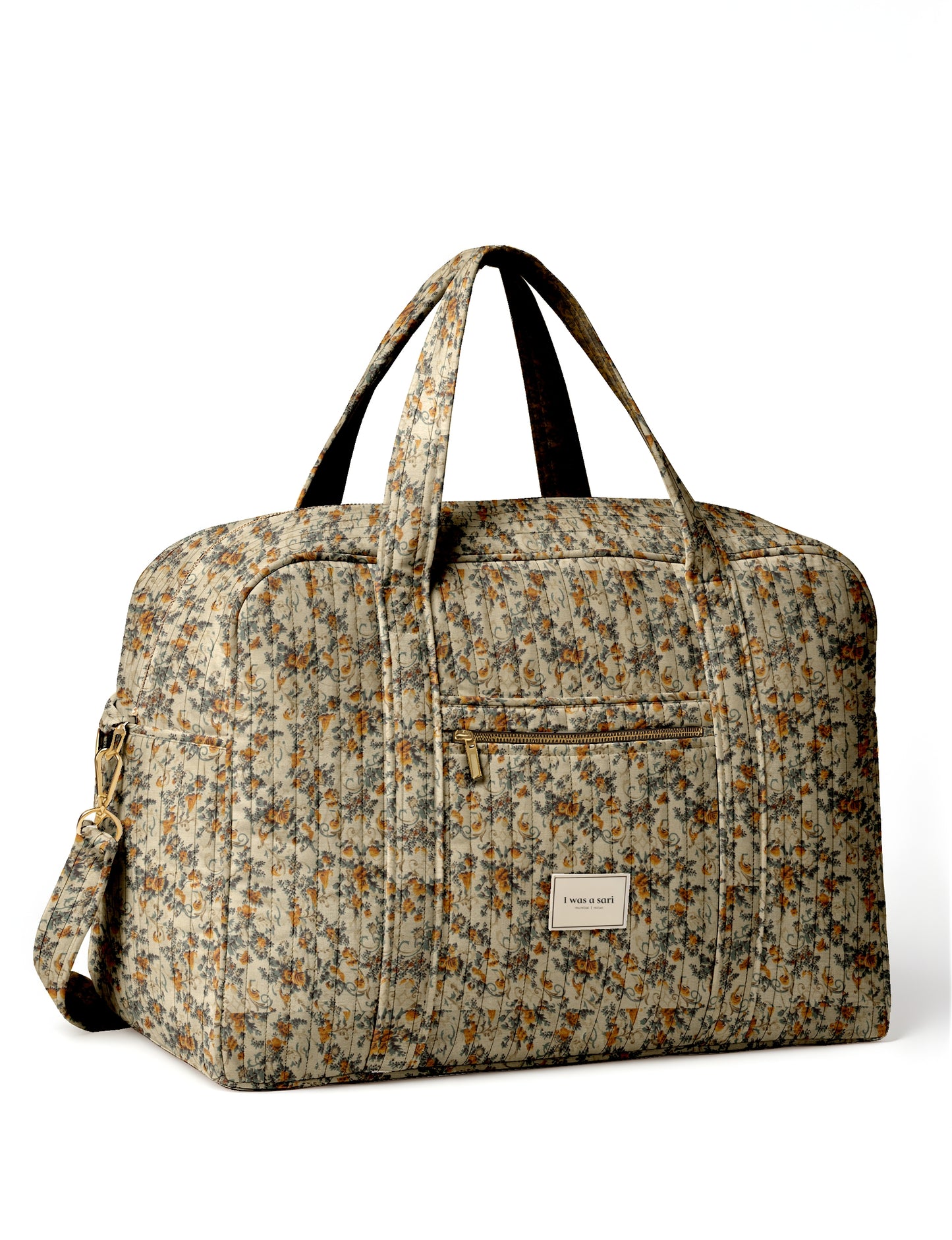 Beige quilted duffle bag with tropical floral pattern, dual handles, front zip pocket, and detachable shoulder strap