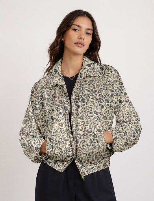 Woman wearing a yellow floral bomber jacket with front zipper, elastic cuffs, and side pockets, shown from front view