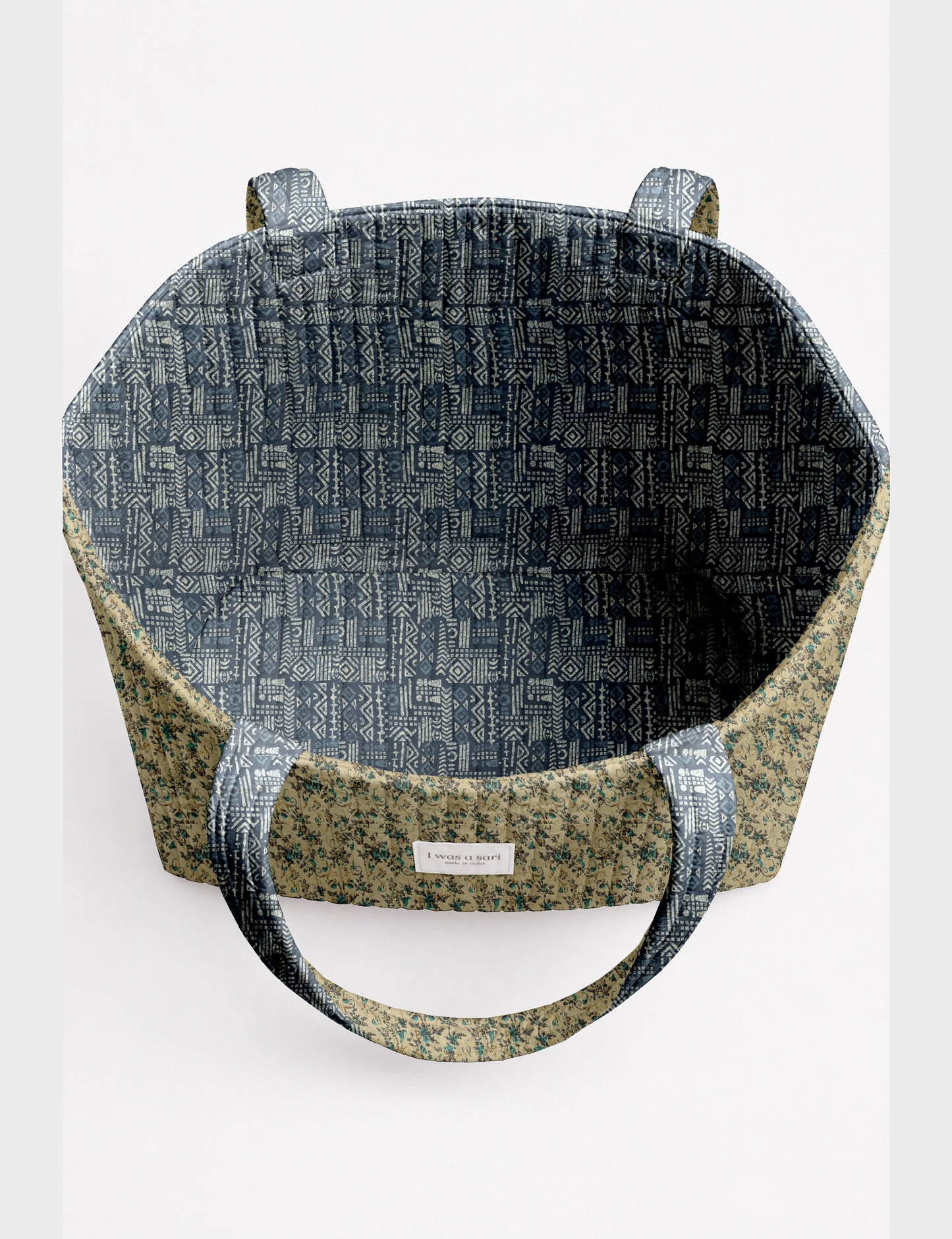 Quilted beach bag with yellow tropical exterior and red patterned interior, shown from top view with handles visible