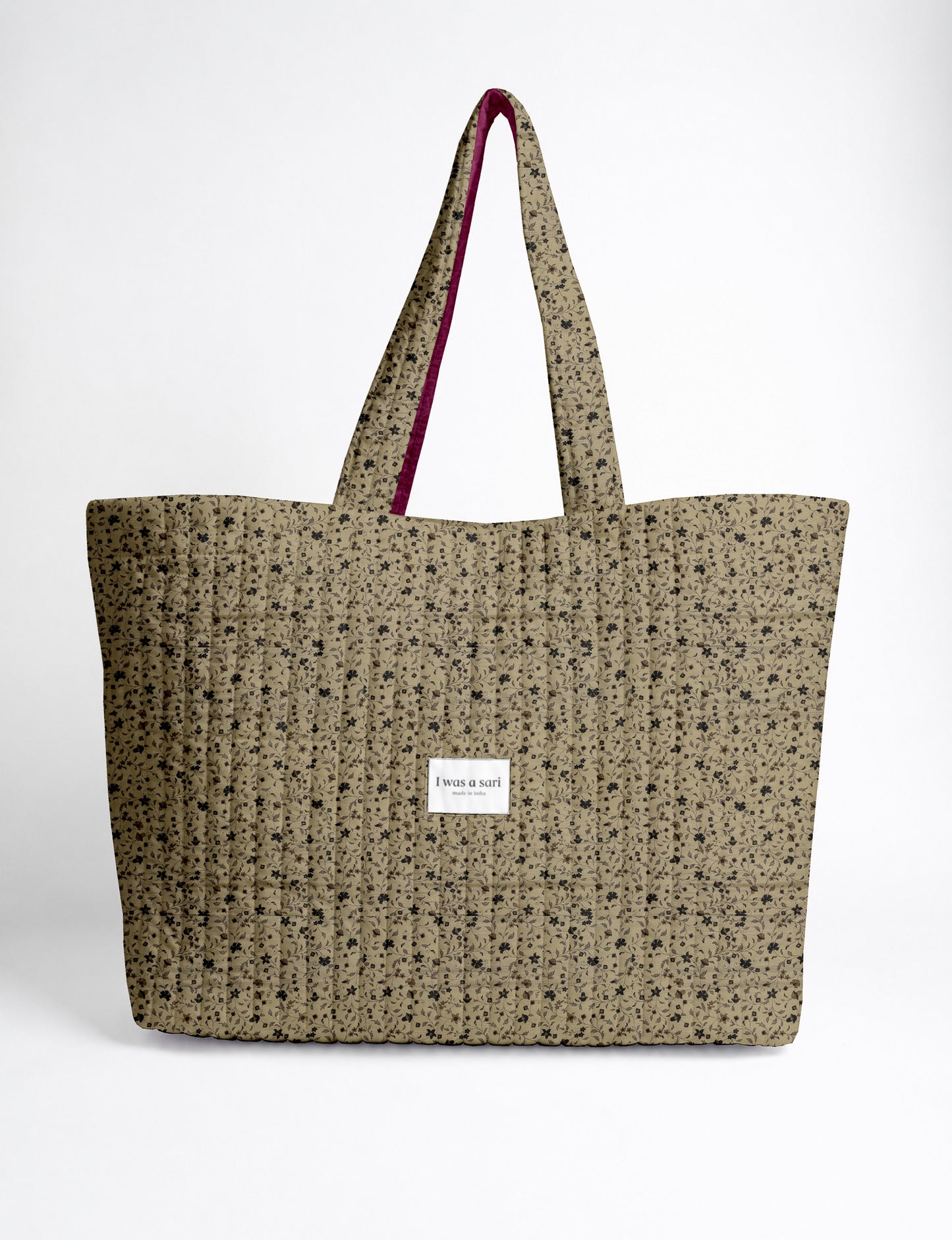 Quilted yellow tropical patterned beach bag with long handles and white label reading "I was a sari" front view