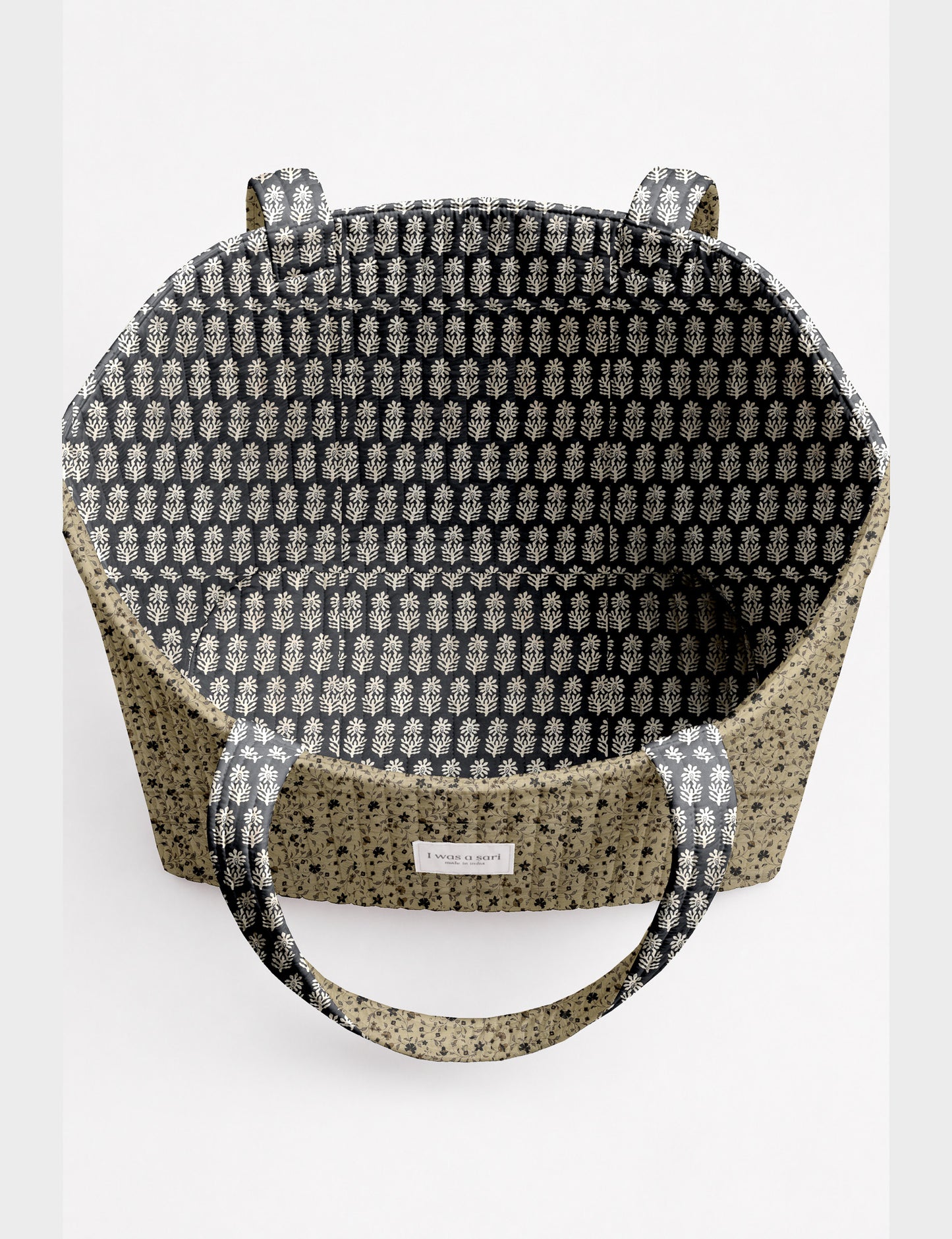 Quilted beach bag with yellow tropical exterior and red patterned interior, shown from top view with handles visible