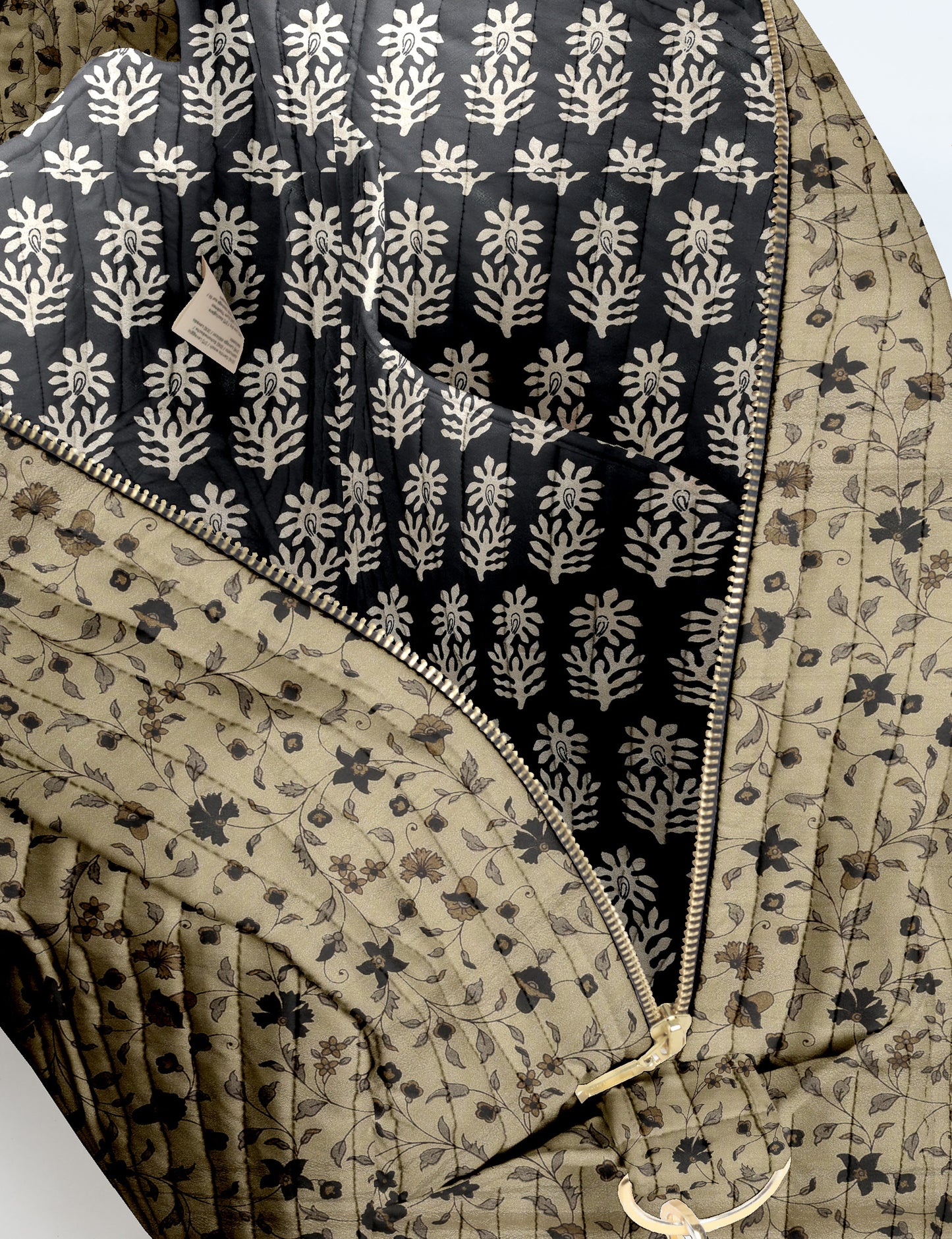 Brown quilted duffle bag with paisley pattern, front zip pocket, dual handles, and label reading "I was a sari"