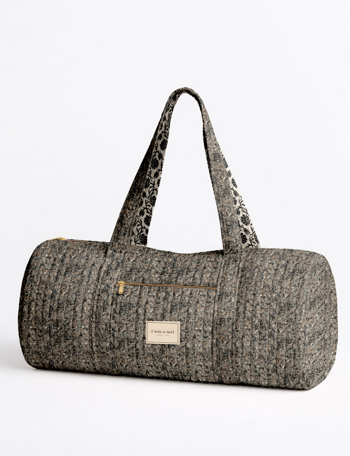 Quilted bowling bag in black abstract pattern with dual handles, front zipper pocket, and "I was a sari" label on front