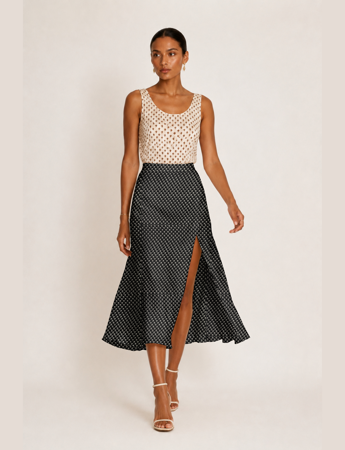 Woman wearing a yellow and black micro patterned A-line skirt with front slit, paired with beige sleeveless top and black