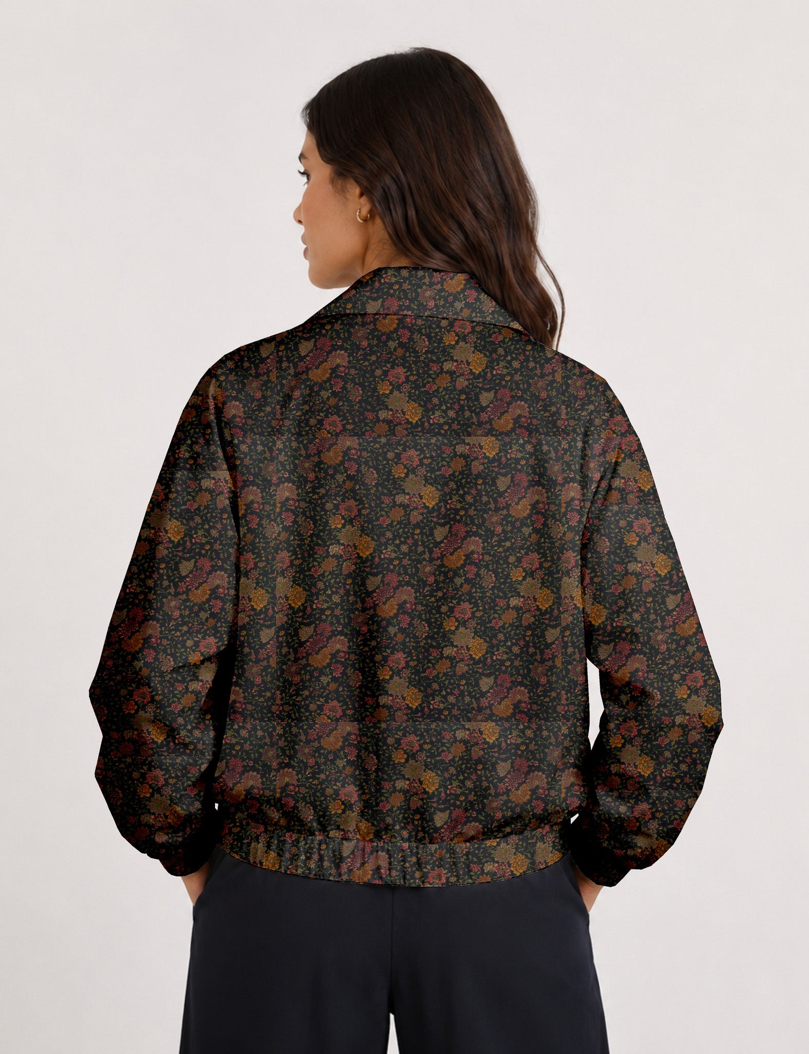 Woman wearing a yellow floral bomber jacket with front zipper, elastic cuffs, and side pockets, shown from front view