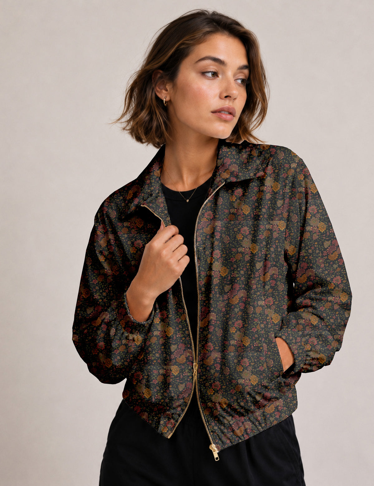 Woman wearing a yellow floral bomber jacket with front zipper, elastic cuffs, and side pockets, shown from front view