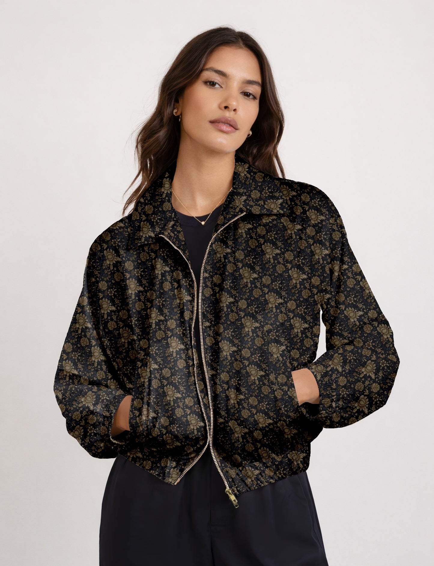 Woman wearing a yellow bomber jacket with a micro geometric pattern, front zipper, and side pockets, paired with black pants