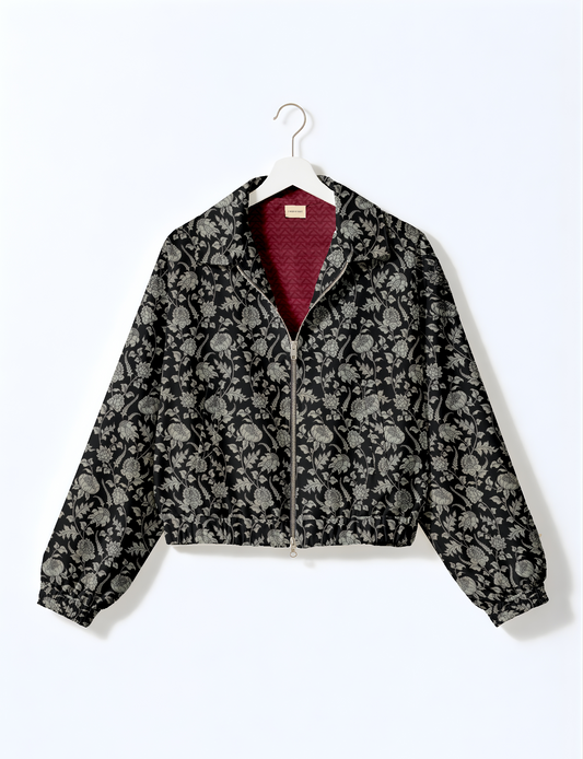 Women's cropped bomber jacket with twin metallic front zippers, welt pockets, elasticated hem and cuffs, and contrast sari print lining.