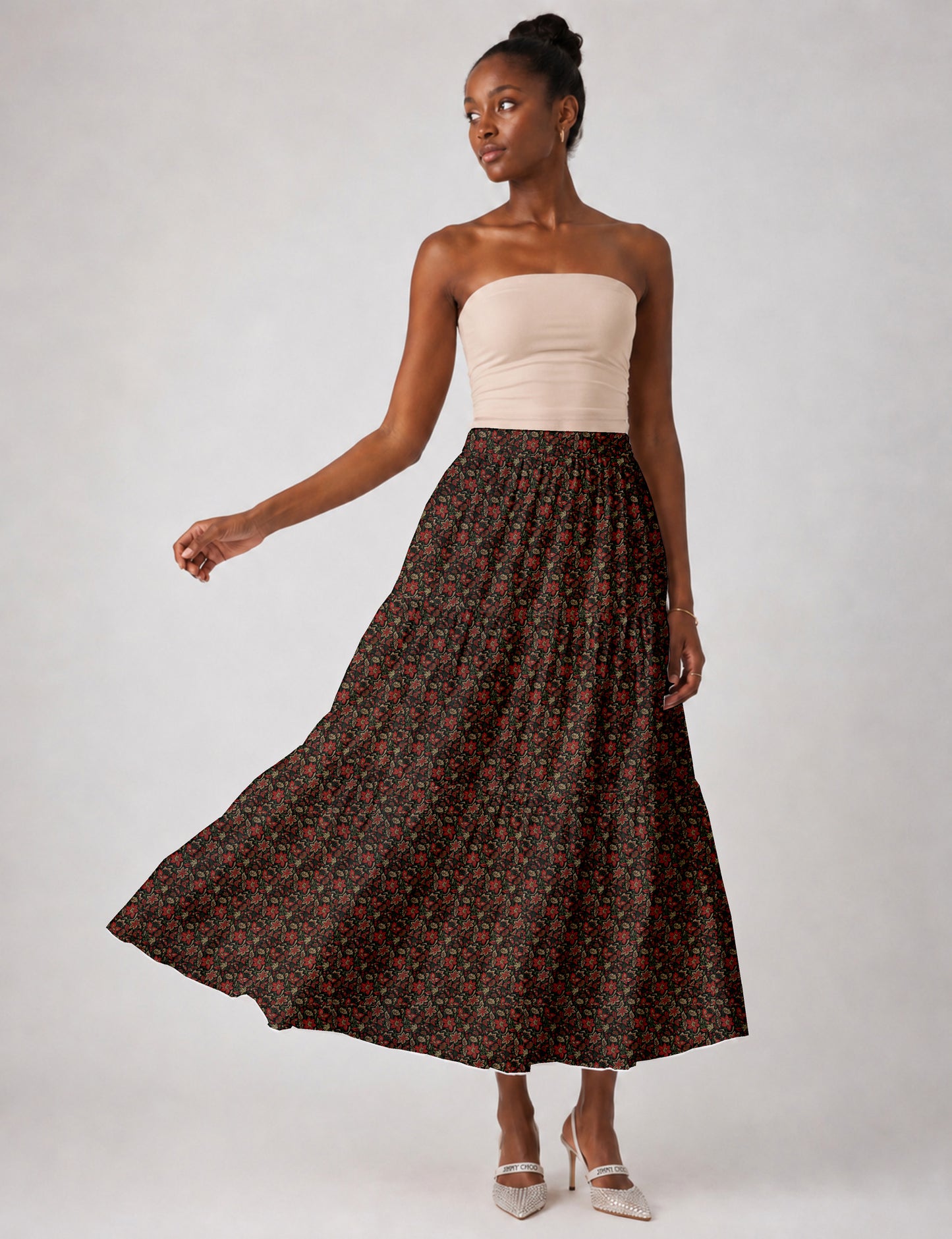 Woman wearing a yellow midi tiered skirt with a small geometric pattern, paired with a beige strapless top and white heels