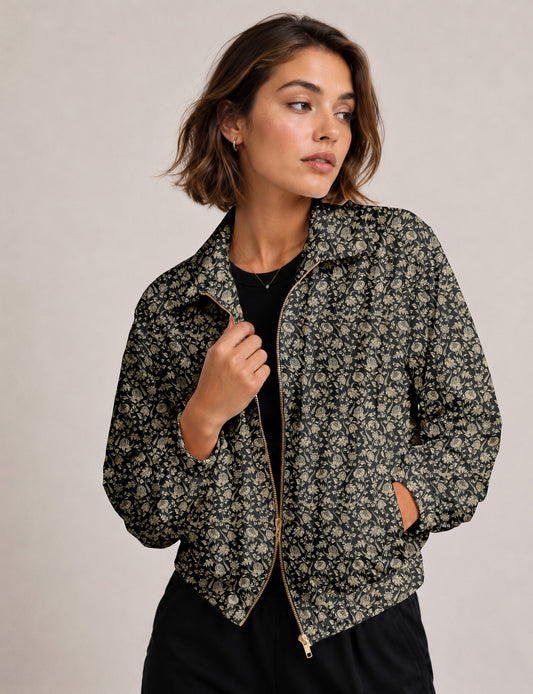 Woman wearing a yellow floral bomber jacket with front zipper, elastic cuffs, and side pockets, shown from front view