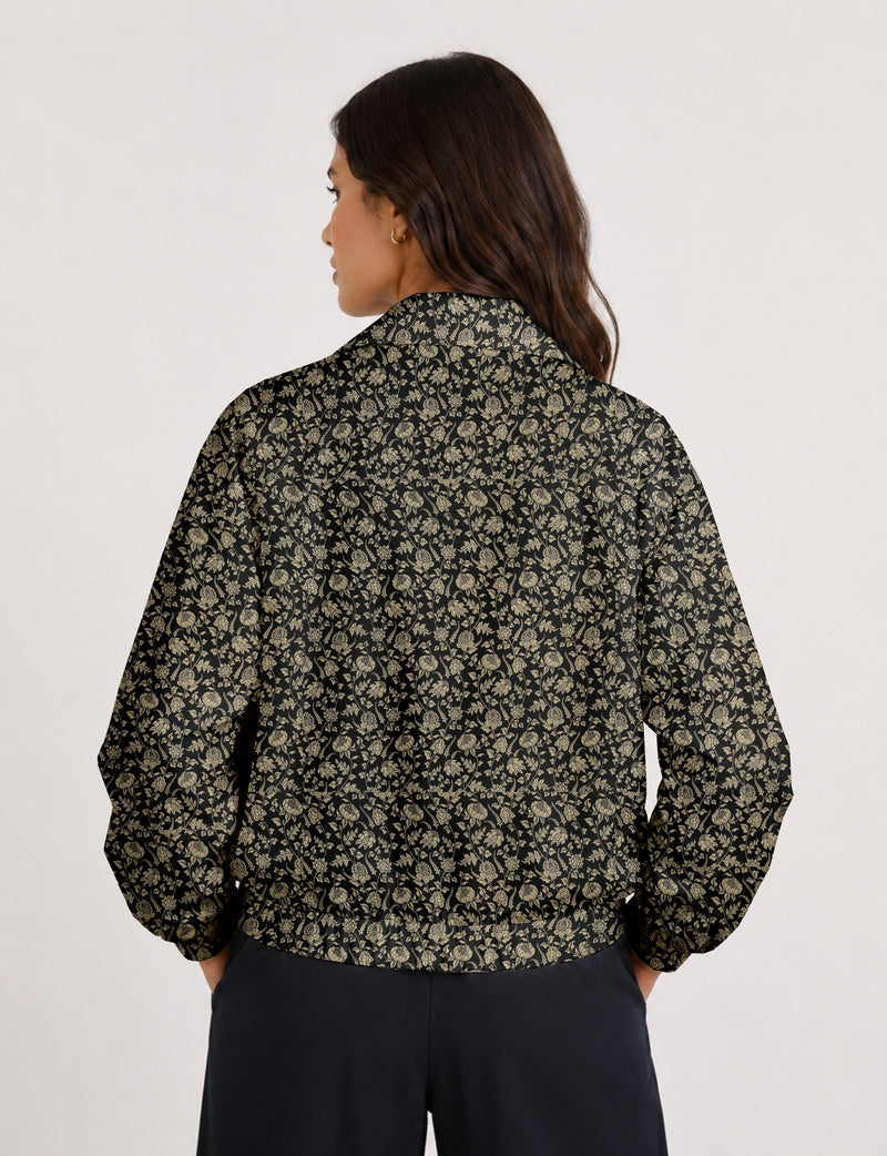Woman wearing a yellow floral bomber jacket with front zipper, elastic cuffs, and side pockets, shown from front view
