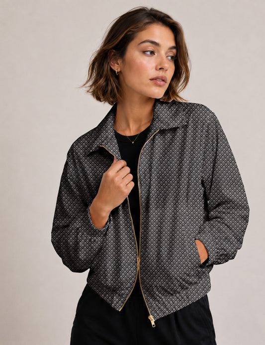 Woman wearing a yellow floral bomber jacket with front zipper, elastic cuffs, and side pockets, shown from front view