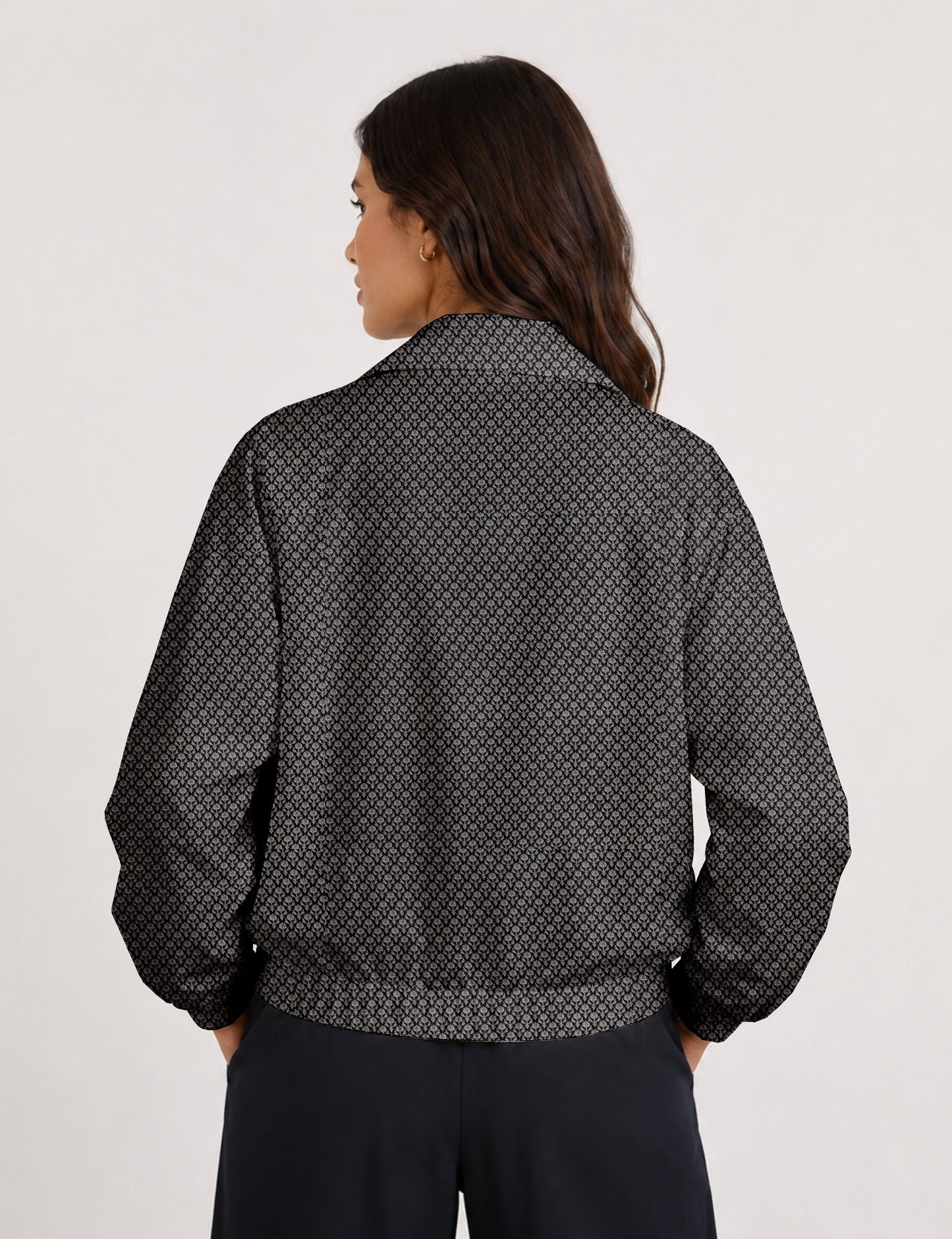 Woman wearing a yellow floral bomber jacket with front zipper, elastic cuffs, and side pockets, shown from front view
