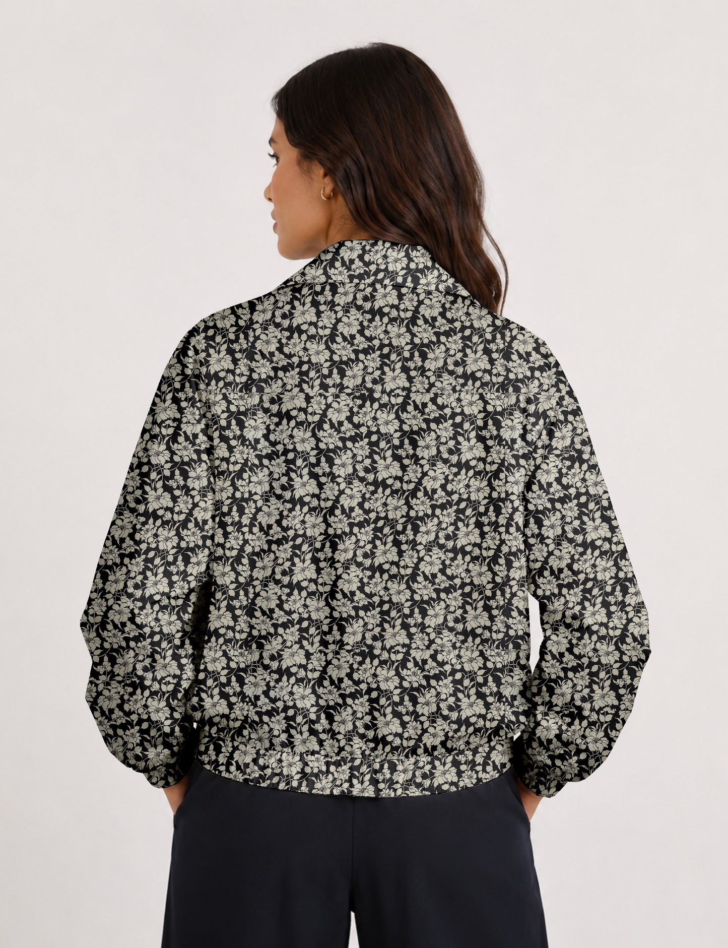 Brown floral bomber jacket with front zipper, elastic cuffs and hem, hanging on white hanger, red floral inner lining visible