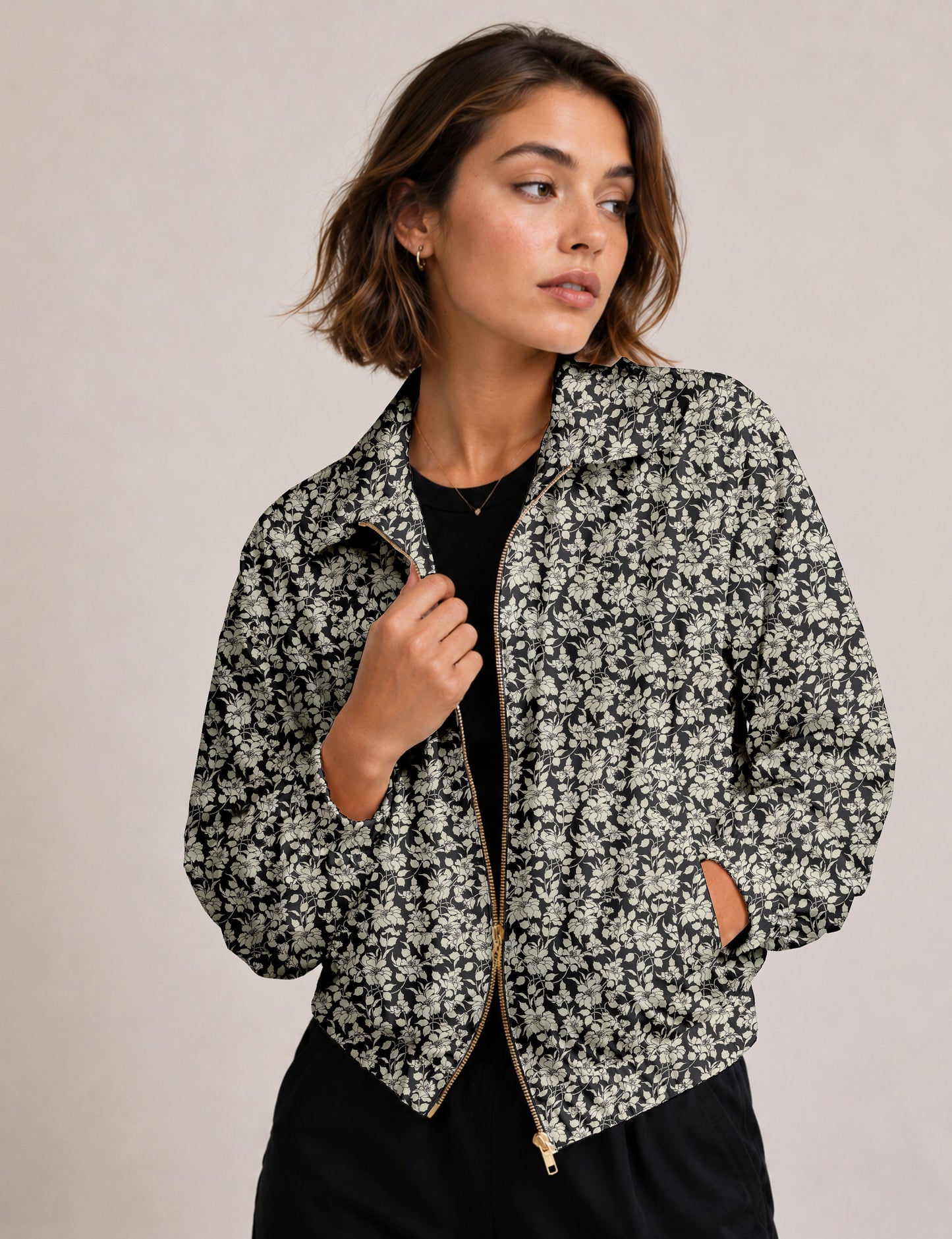 Woman wearing a yellow floral bomber jacket with front zipper, elastic cuffs, and side pockets, shown from front view