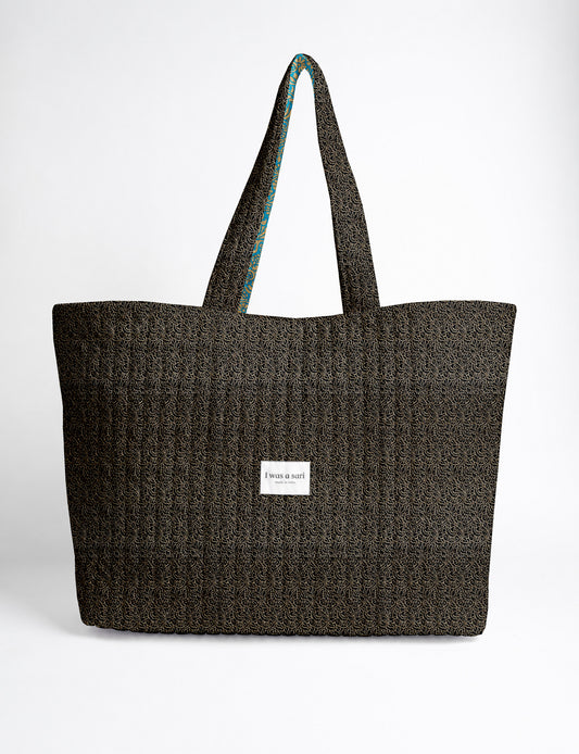 Quilted yellow tropical patterned beach bag with long handles and white label reading "I was a sari" front view