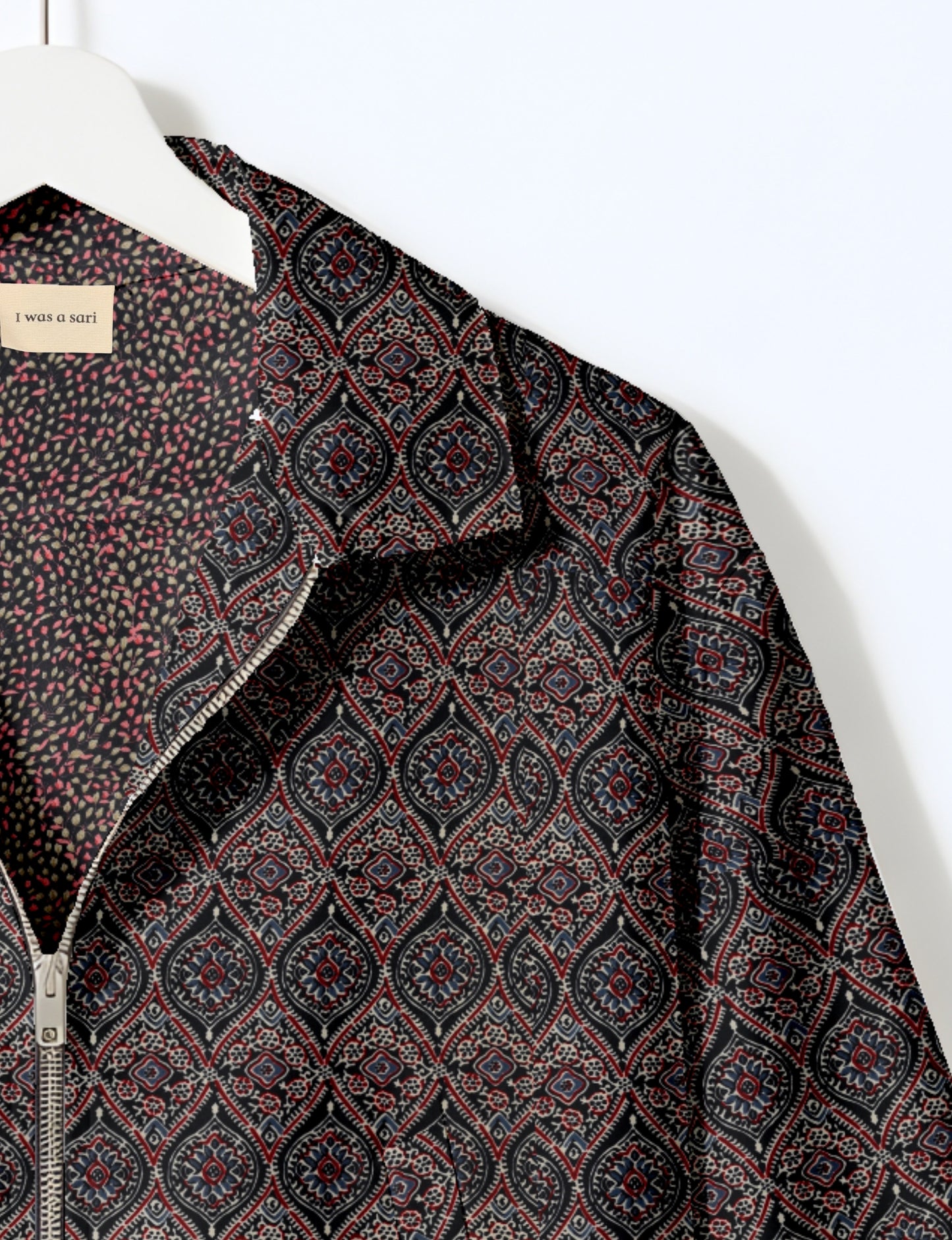 Women's cropped bomber jacket with twin metallic front zippers, welt pockets, elasticated hem and cuffs, and contrast sari print lining.