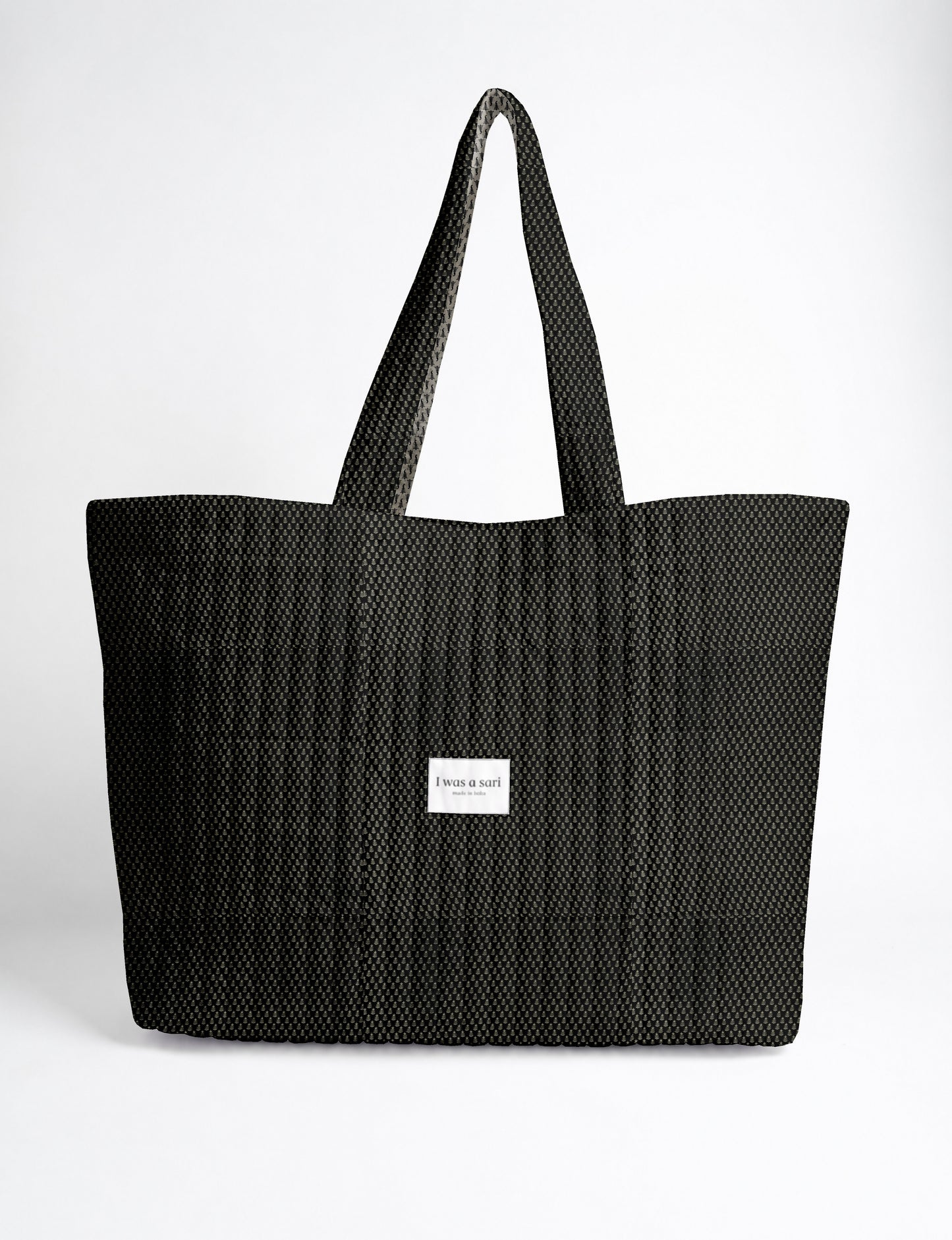 Large quilted beach bag with spacious rectangular design, reinforced shoulder straps, and open-top construction for everyday use and travel.
