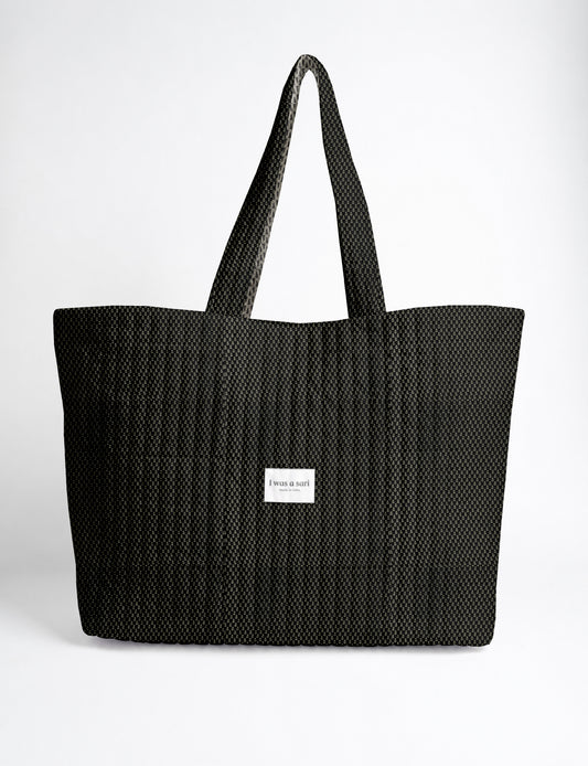 Large quilted beach bag with spacious rectangular design, reinforced shoulder straps, and open-top construction for everyday use and travel.