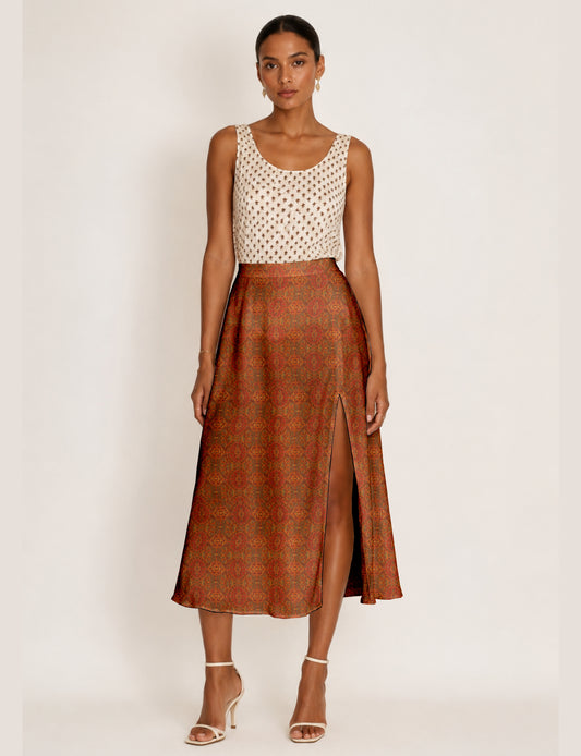 Woman wearing a yellow and black micro patterned A-line skirt with front slit, paired with beige sleeveless top and black