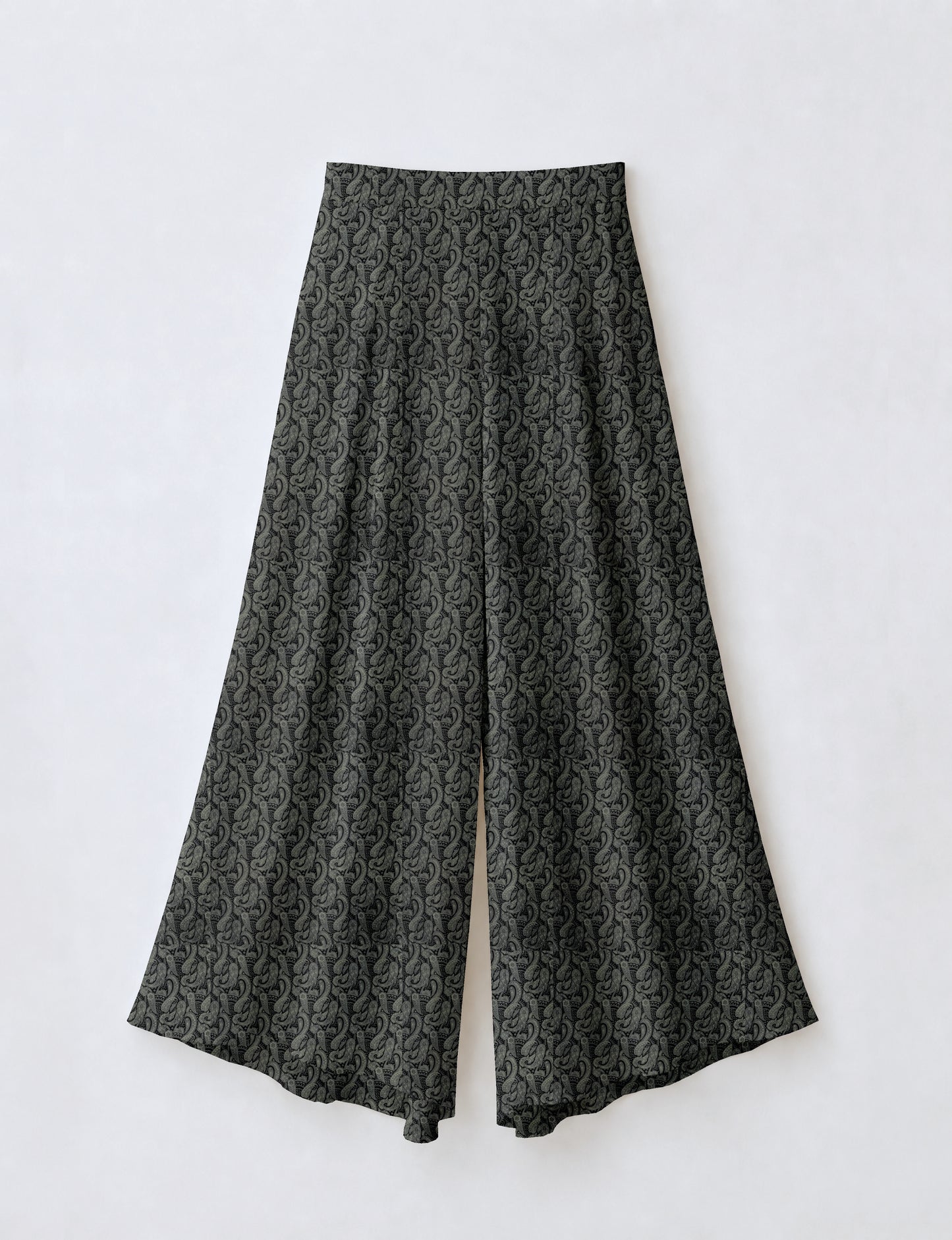 Woman wearing blue wide leg palazzo trousers with black and brown floral print, paired with brown sleeveless top and white